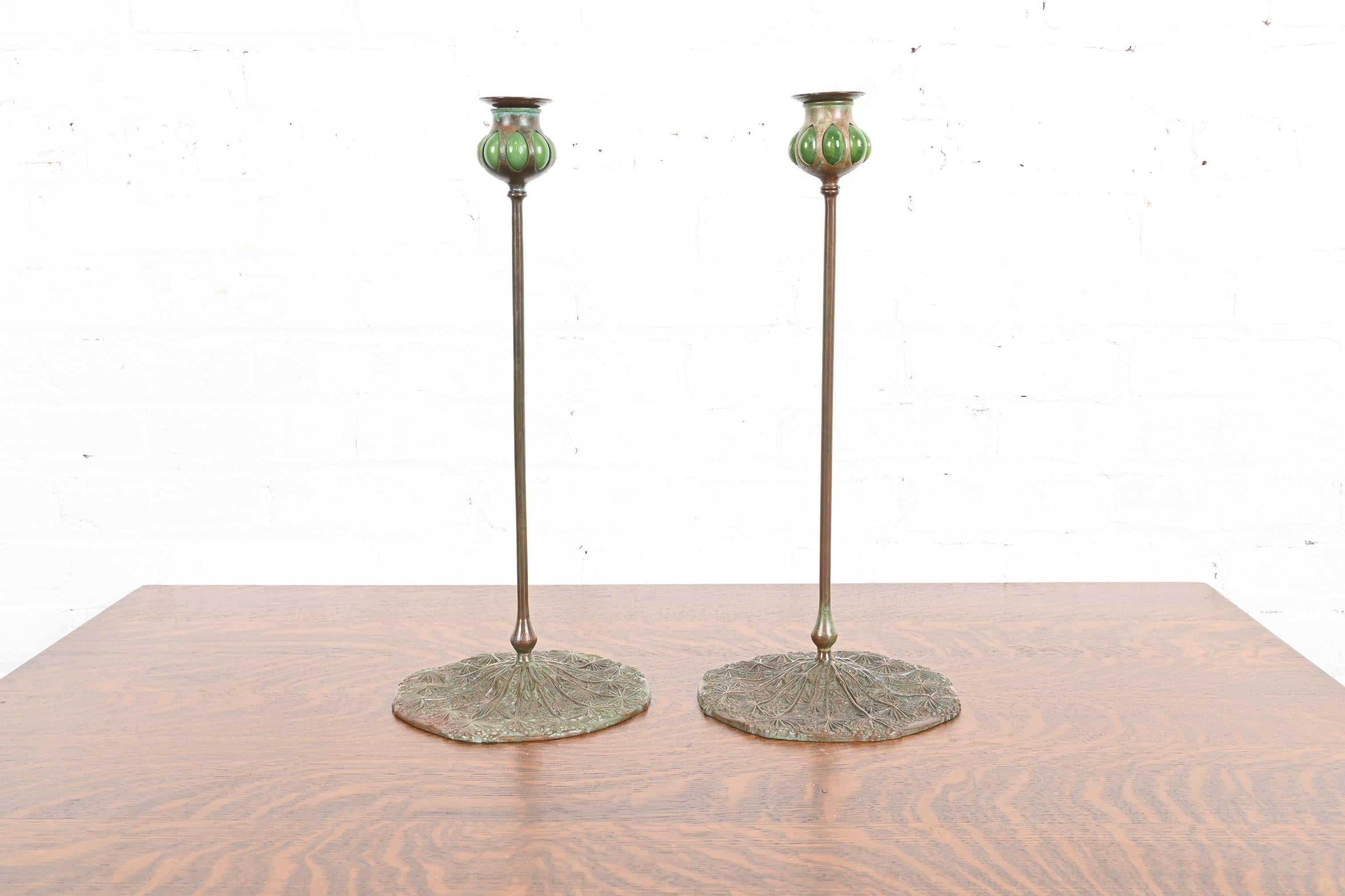 Una splendida coppia di candelabri in bronzo e vetro verde Favrile Wild Carrot soffiati in stile Arts & Crafts o Art Nouveau

Di Tiffany Studios (firmato sul lato inferiore)

New York, USA, inizio del XX secolo

Ciascuna misura: 8,25