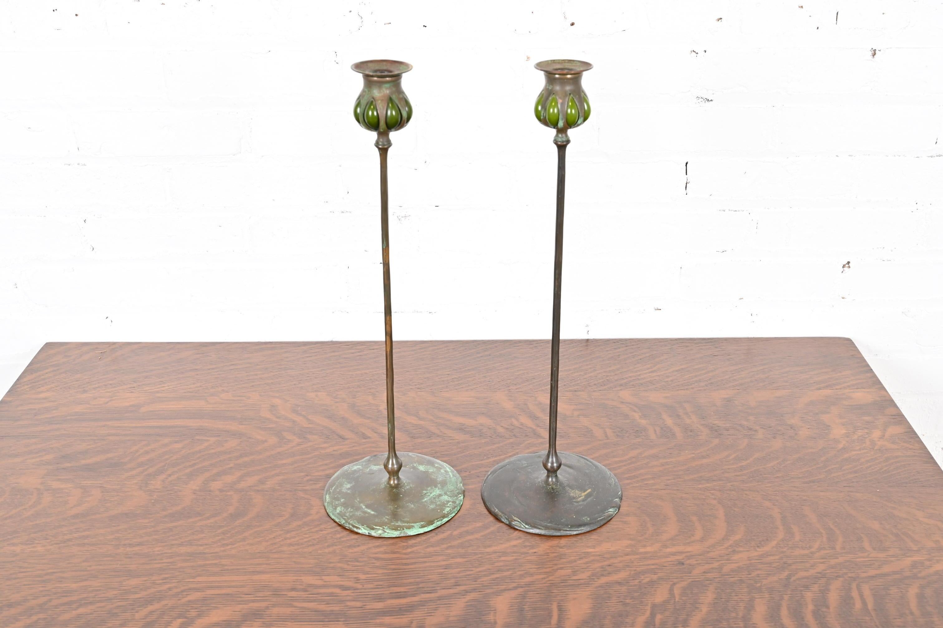A gorgeous pair of Arts & Crafts or Art Nouveau period bronze and green favrile glass puddle candlesticks

By Tiffany Studios

New York, USA, Early 20th Century

Measures: 5.75