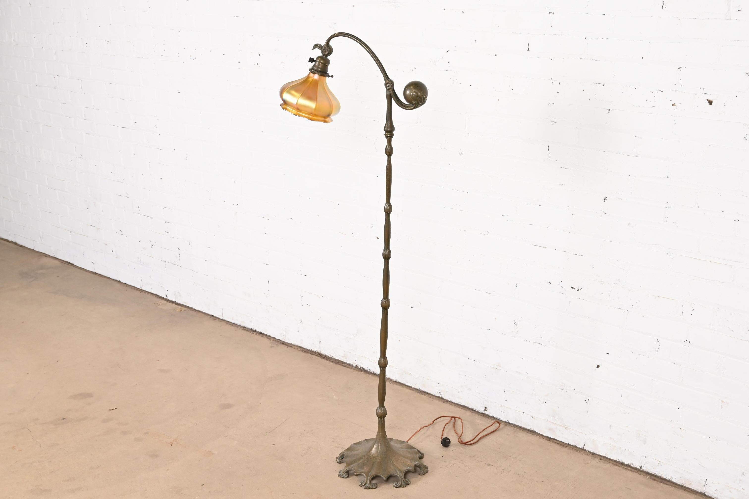 An outstanding Arts & Crafts or Art Deco period bronze counterbalance floor lamp 

By Tiffany Studios (signed under one foot)

New York, USA, Early 20th Century

Bronze stand, with gorgeous Quezal iridescent favrile glass shade.

Measures: 18