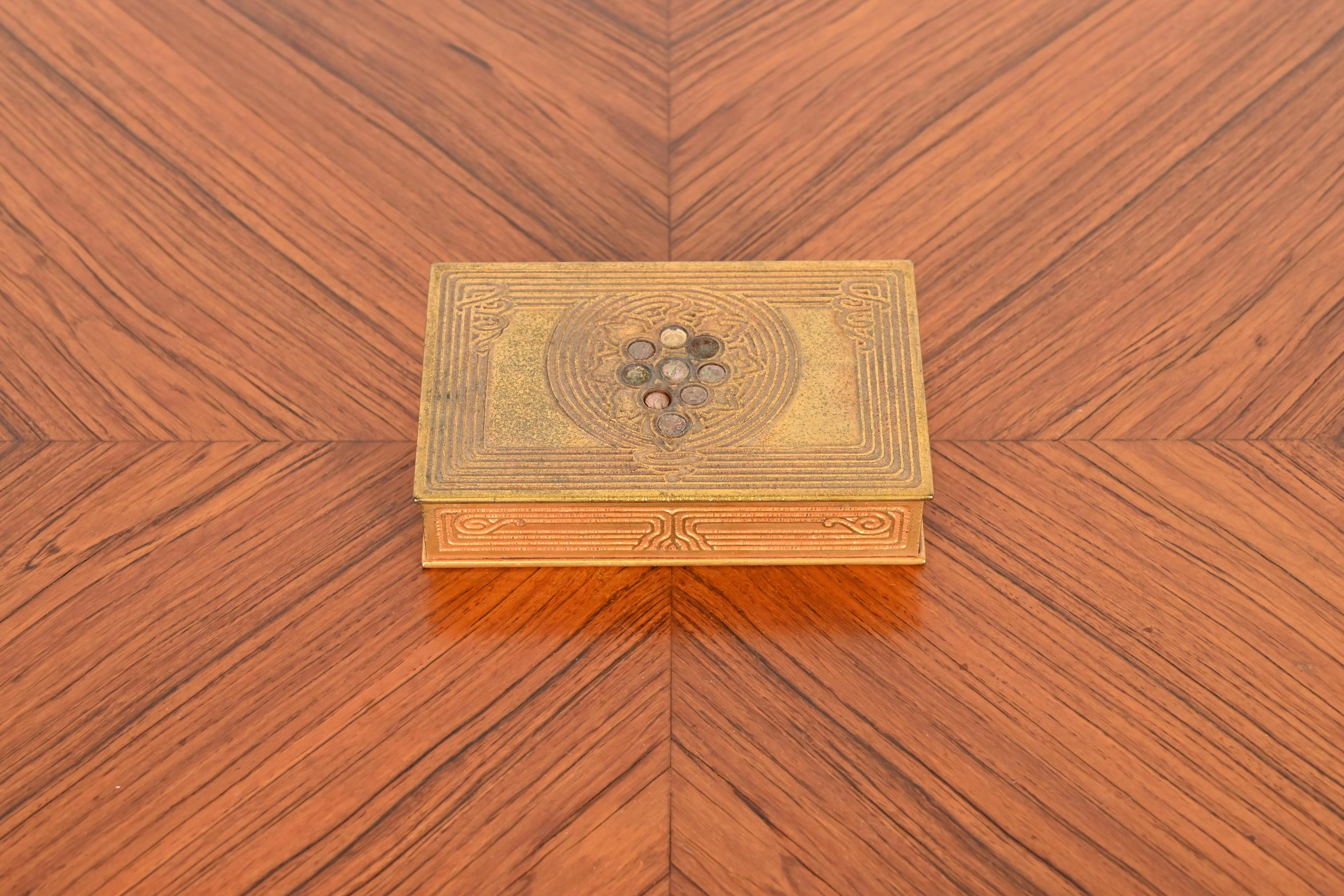 Magnifique boîte à cigarettes, boîte de bureau ou boîte à bijoux en bronze doré et ormeaux incrustés d'époque Art déco.

Par Tiffany Studios

New York, États-Unis, début du XXe siècle

Dimensions : 5,5 