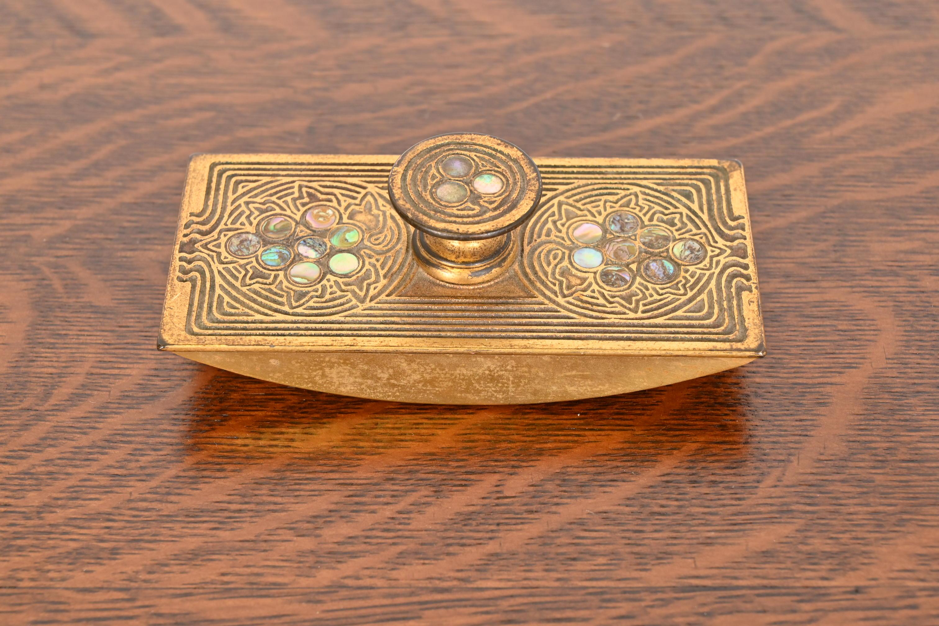 Uno splendido calamaio a dondolo in bronzo dorato e abalone intarsiato di epoca Art Nouveau o Art Deco

Da Tiffany Studios

New York, USA, inizio del XX secolo

Misure: 5,75