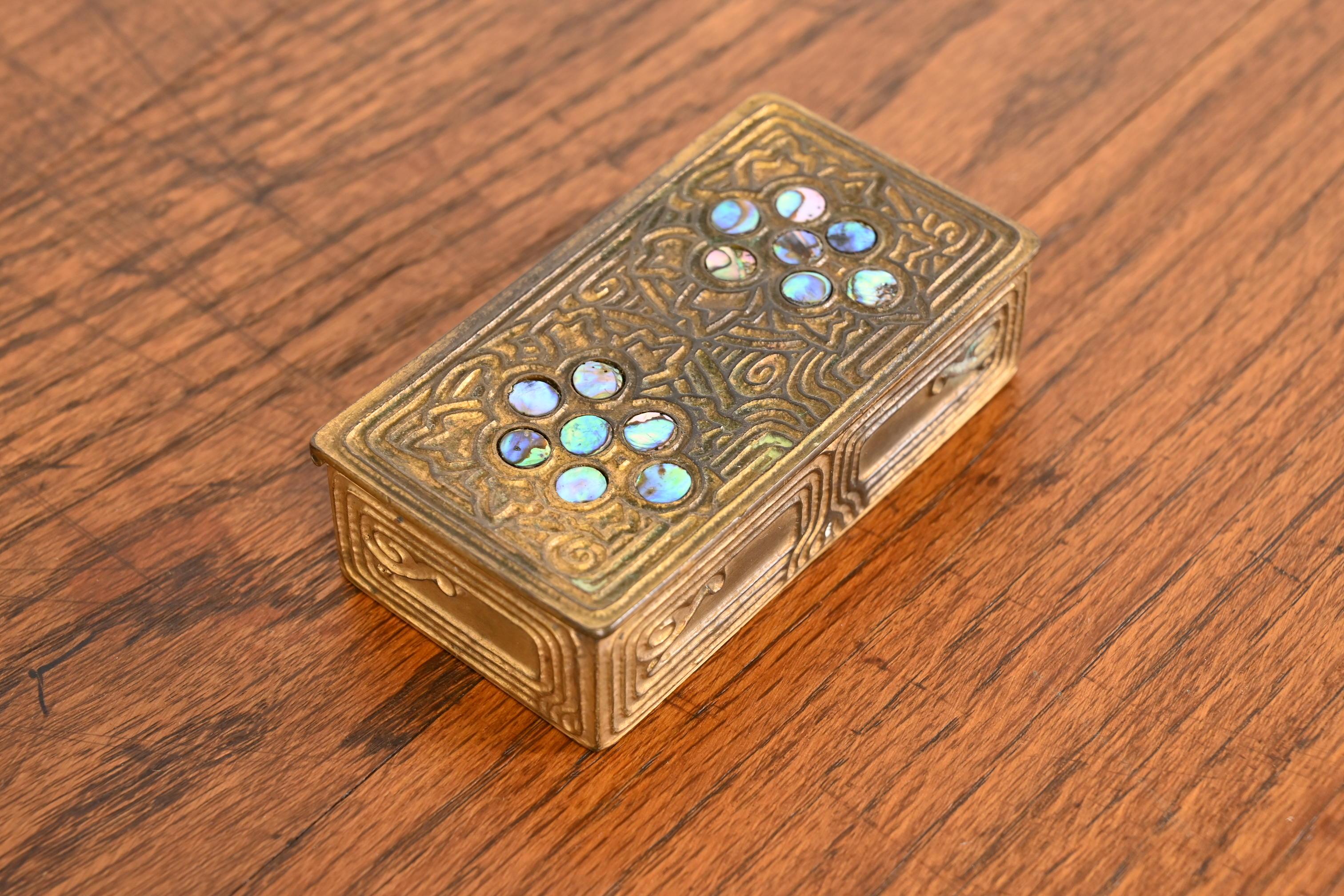 A gorgeous Art Nouveau or Art Deco period gilt bronze and inlaid abalone stamp box

By Tiffany Studios

New York, USA, early 20th century

Measures: 4