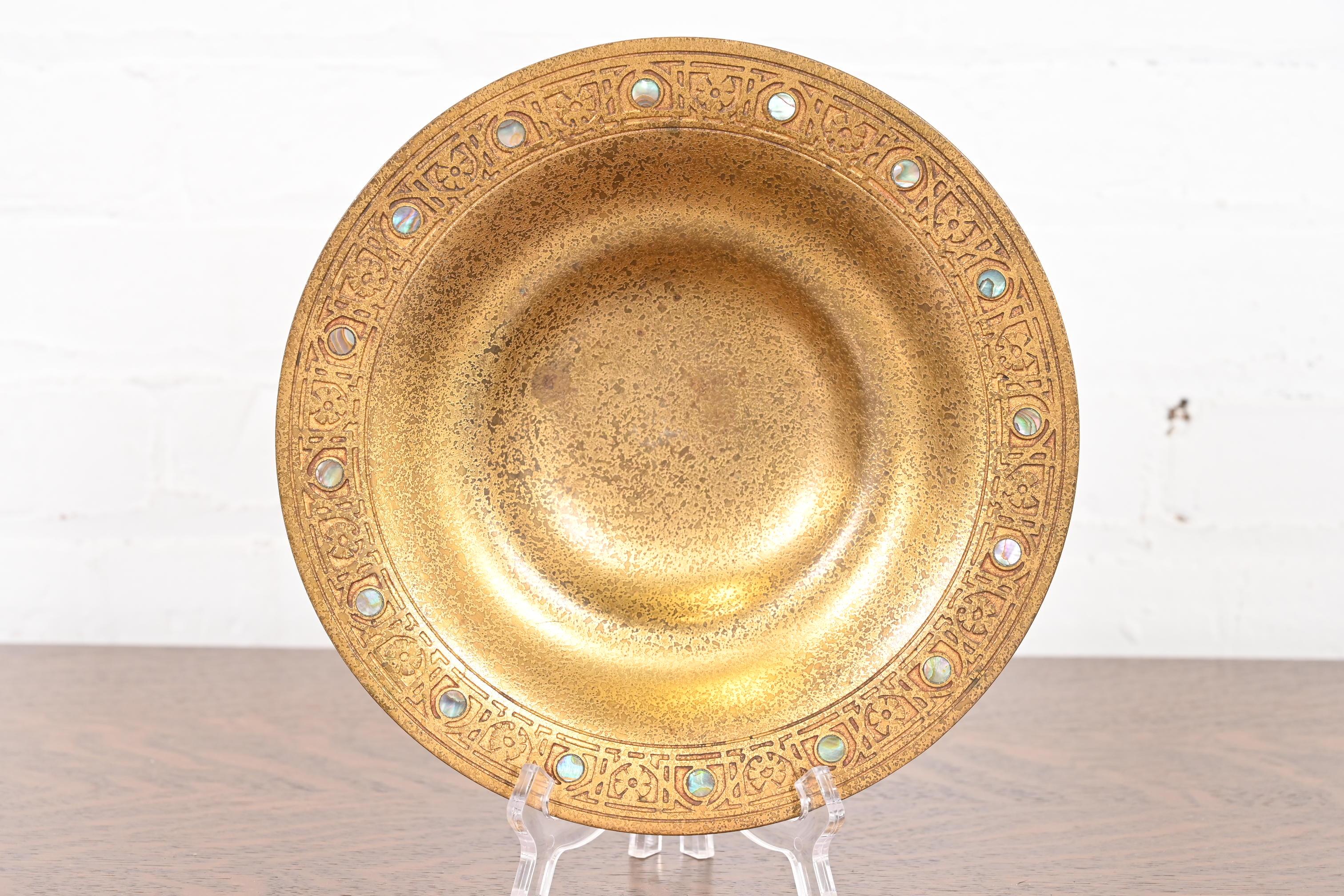 Magnifique plat ou bol peu profond en bronze doré d'époque Arts & Crafts ou Art Deco avec incrustation d'abalone.

Par Tiffany Studios (signé sur le dessous)

New York, États-Unis, Début du XXe siècle

Dimensions : 9,13 