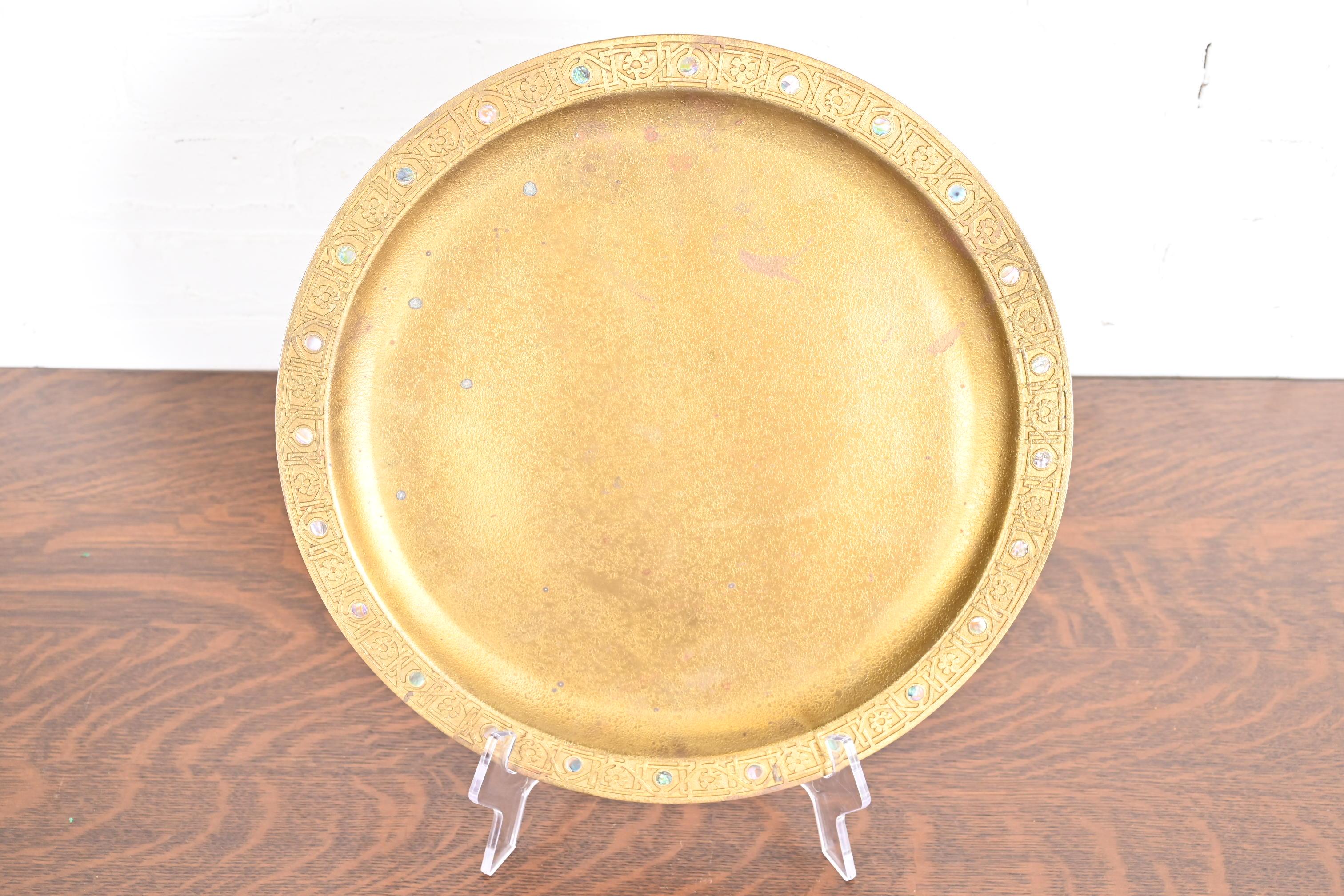 A gorgeous Arts & Crafts or Art Deco period gilt bronze large charger plate or serving tray with abalone inlay

By Tiffany Studios (signed to the underside)

New York, USA, Early 20th Century

Measures: 14