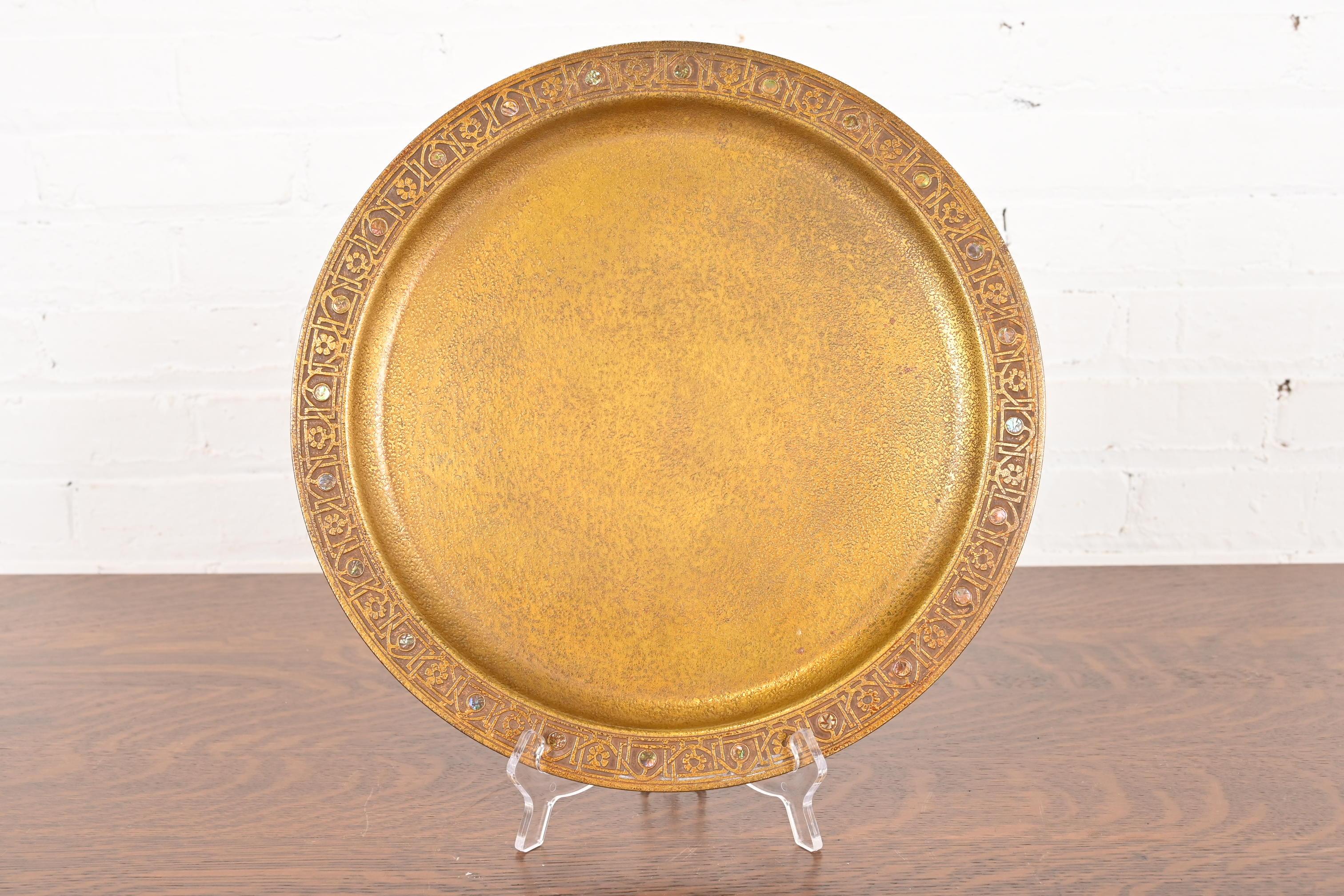 A gorgeous Arts & Crafts or Art Deco period gilt bronze charger plate or serving tray with abalone inlay

By Tiffany Studios (signed to the underside)

New York, USA, Early 20th Century

Measures: 14.13