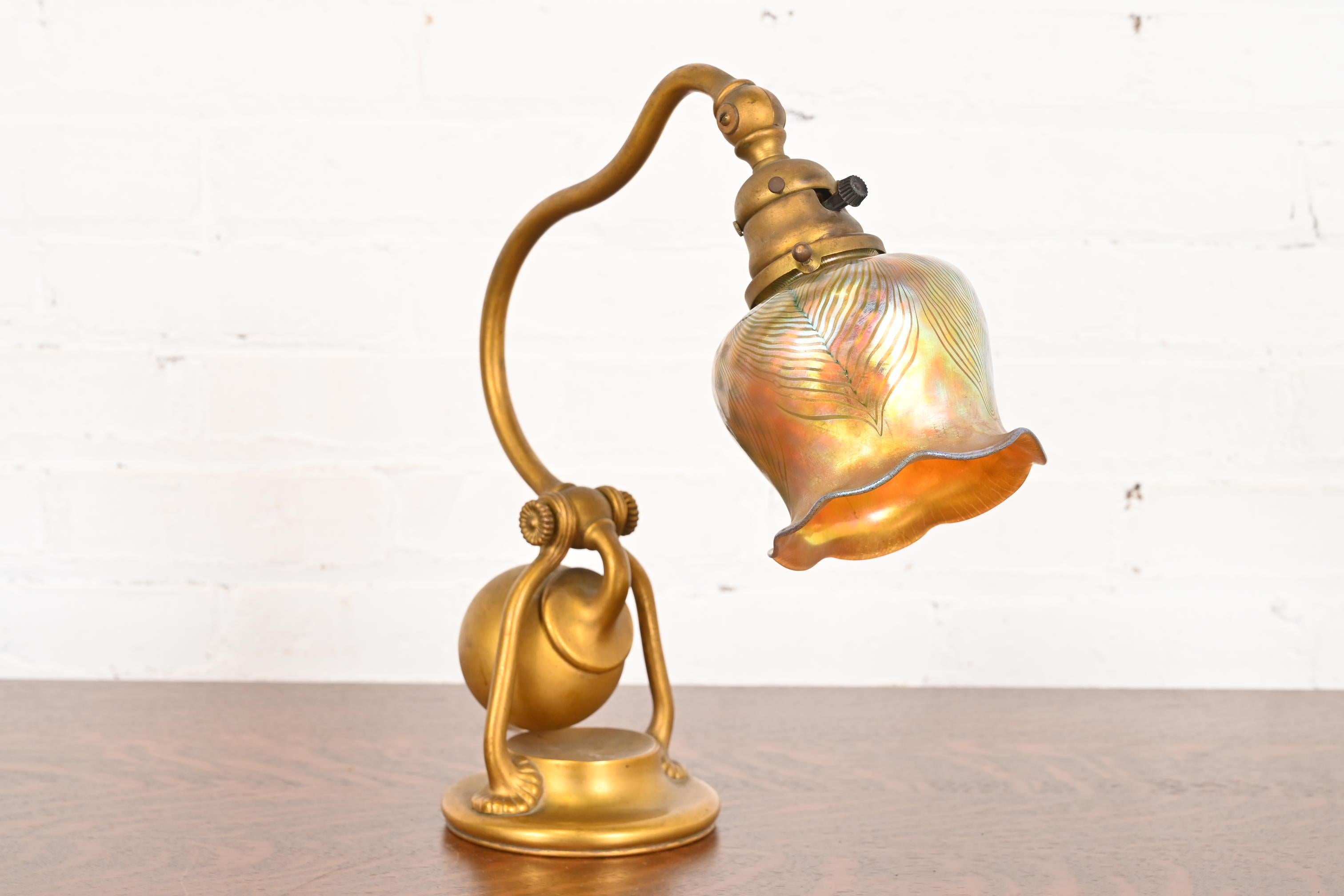 A gorgeous Arts & Crafts or Art Deco period bronze counterbalance desk lamp or table lamp

By Tiffany Studios (signed to the underside of base)

New York, USA, Early 20th Century

Gilt bronze base, with beautiful iridescent Favrile art glass pulled