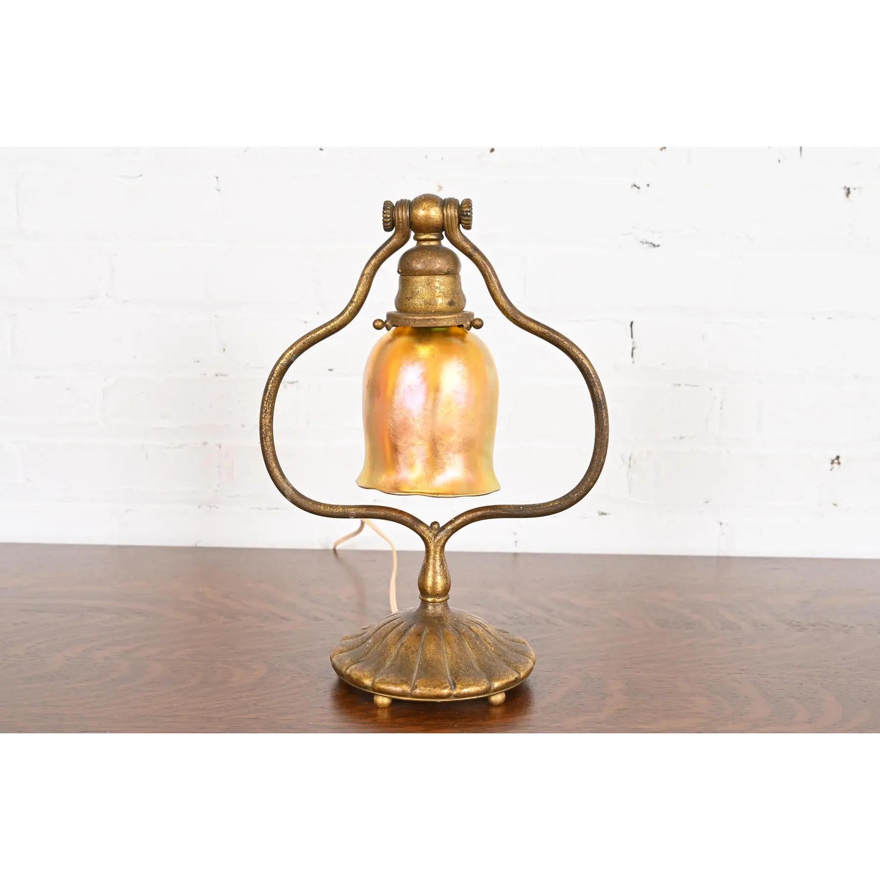 A gorgeous Arts & Crafts or Art Deco period bronze harp desk lamp or table lamp

By Tiffany Studios

New York, USA, Early 20th Century

Gilt bronze base, with beautiful iridescent Favrile art glass shade.

Measures: 9.5
