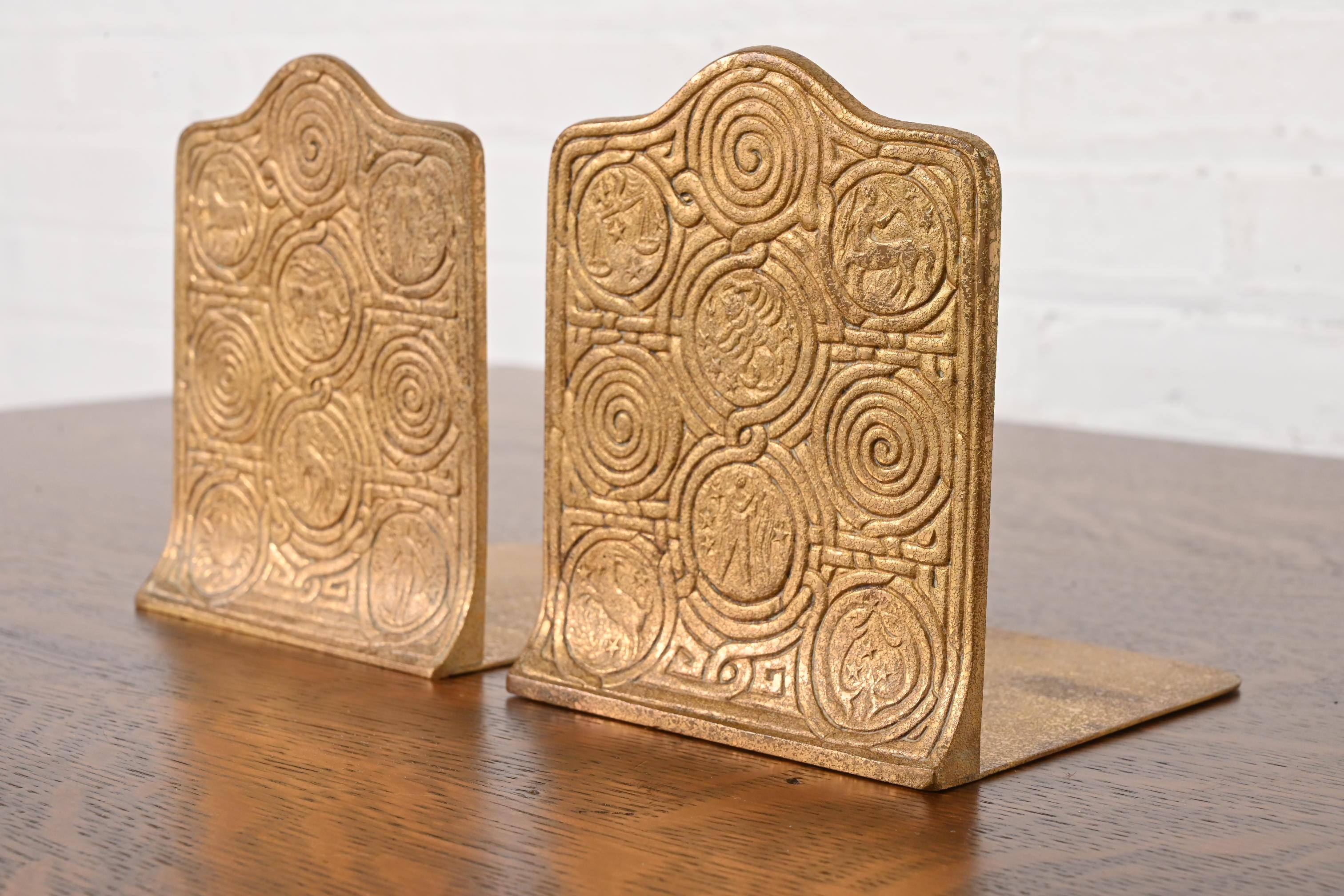 Una splendida coppia di fermalibri in bronzo dorato di epoca Arts & Crafts o Art Déco con disegni dello Zodiac

Di Tiffany Studios (firmato sulla base)

New York, USA, inizio del XX secolo

Ciascuna misura: 5 