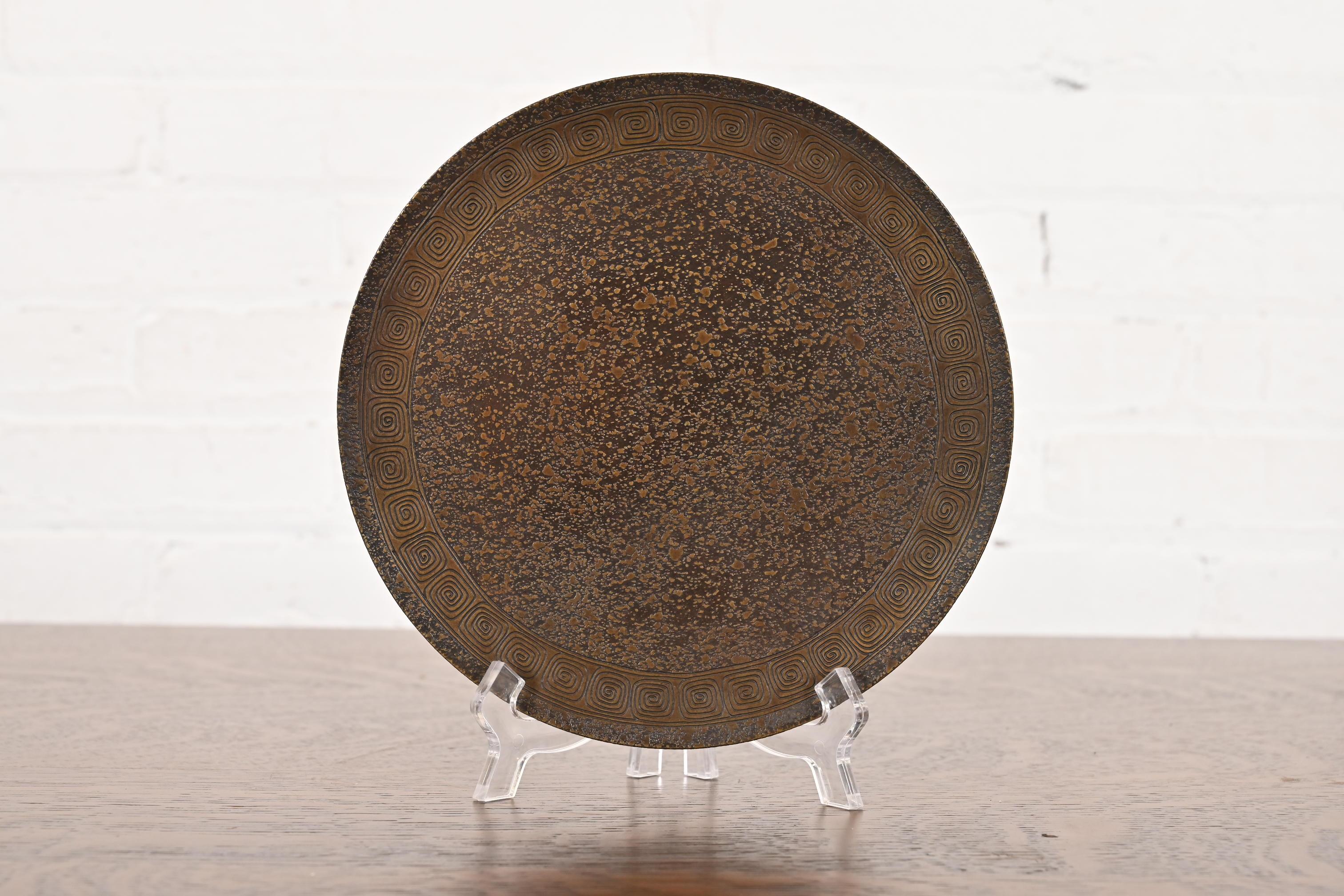 Magnifique assiette, plateau de service ou tazza à pied en bronze patiné d'époque Arts & Crafts ou Art Deco avec motif de clé grecque.

Par Tiffany Studios (signé sur le dessous)

New York, États-Unis, Début du XXe siècle

Dimensions : 8 