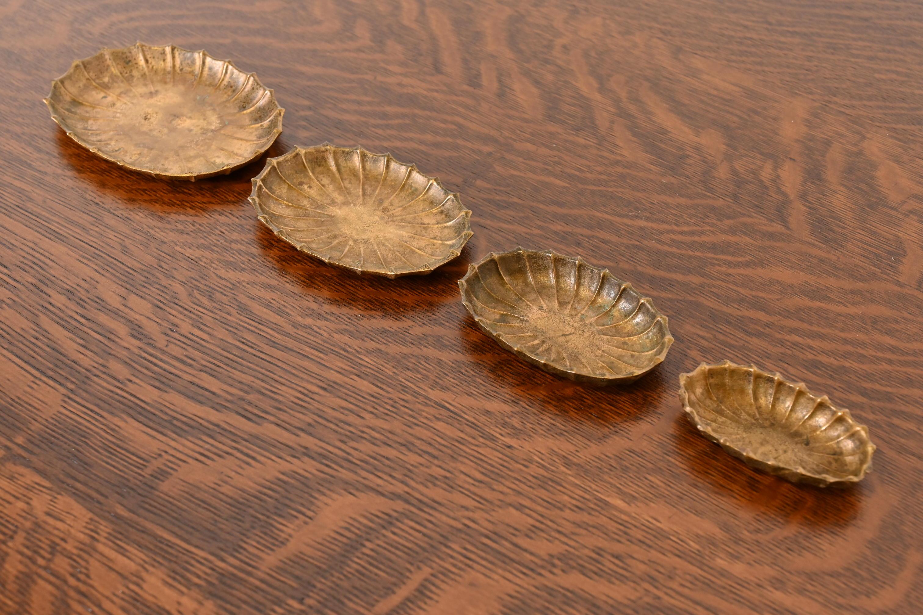 Magnifique ensemble de plateaux gigognes en bronze doré d'époque Arts & Crafts ou Art Deco, avec coquillages moulés et festonnés.

Par Tiffany Studios (signé au-dessous de chaque pièce)

New York, États-Unis, Début du XXe siècle

Du plus grand au