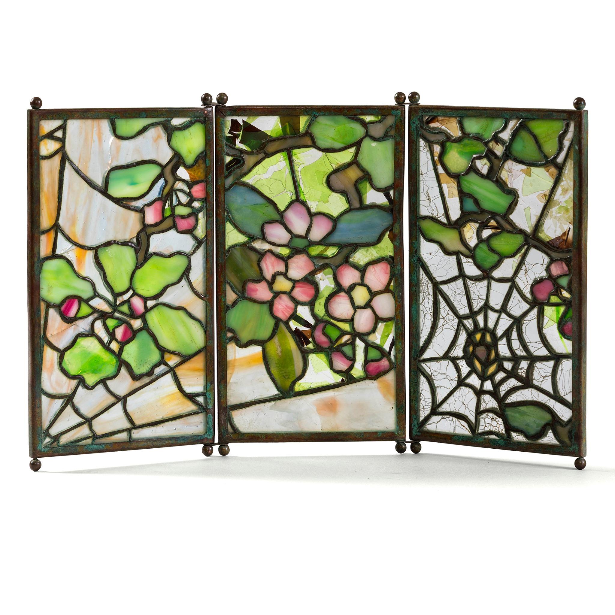 Tiffany Studios was renowned for transforming everyday household objects into works of art. This tea screen, while functional in shielding the flame beneath a teapot, was conceived primarily as an ornamental piece, inspired by the byōbu, or