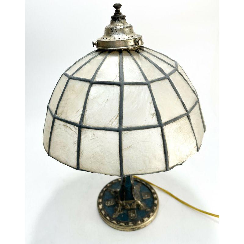 Tiffany Studios New York cold painted bronze lamp in heraldic blue #691

Wrinkled texture with applied armorial Coat of Arms of three lions. Tiffany Studios mark to the underside base. Lampshade made of Mother of Pearl paneled period shade,