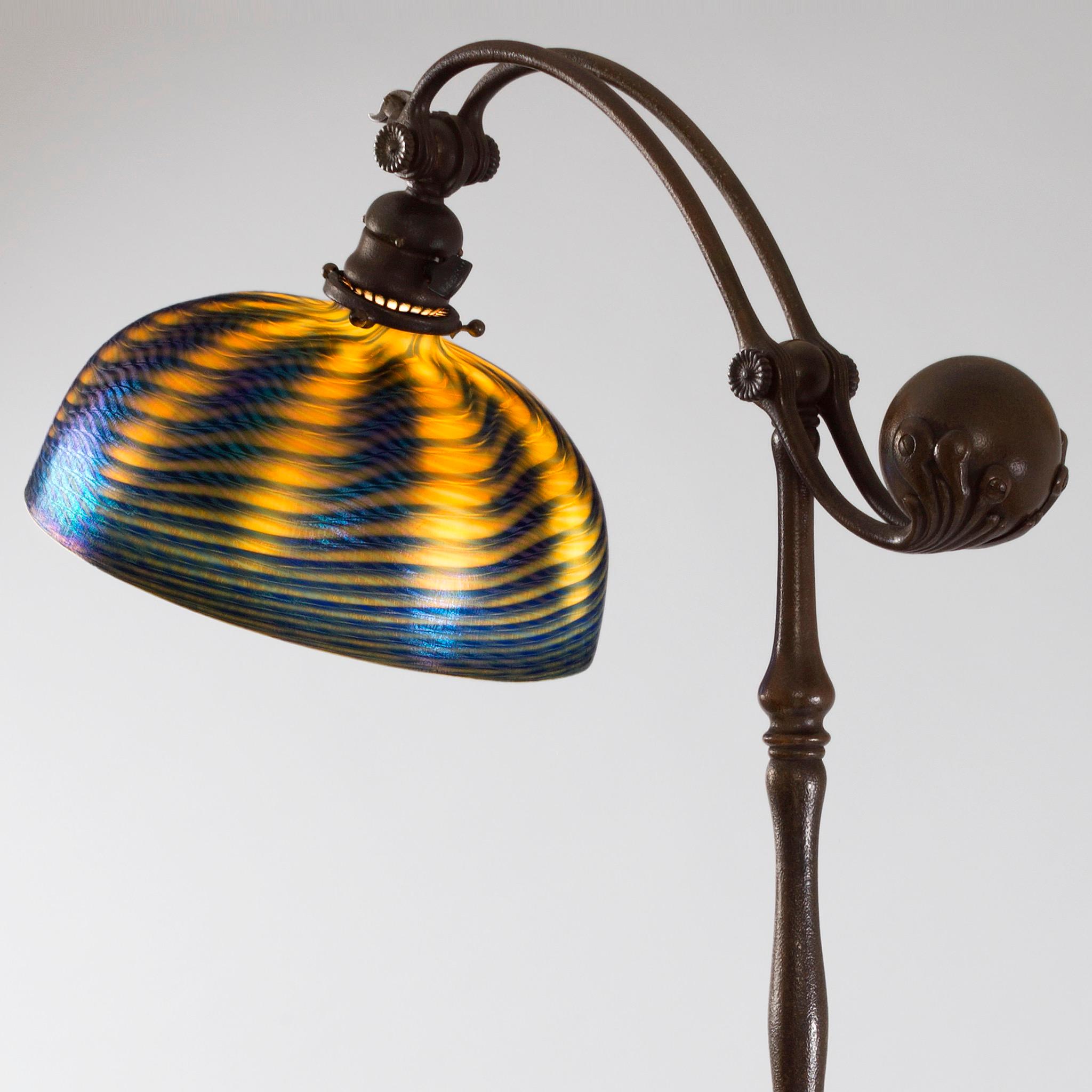 This Tiffany Studios New York glass and bronze floor lamp, features a shimmering twisted midnight blue and amber 