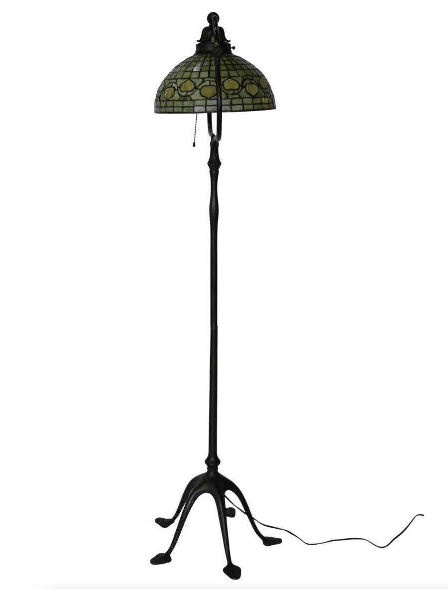 Tiffany Studios New York patinated bronze and Favrile glass floor lamp. The lamp has a green 