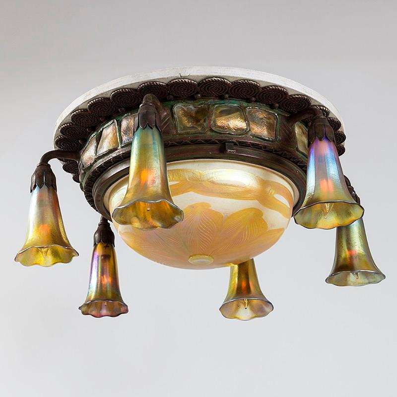 This Tiffany Studios New York Favrile glass and gilt-bronze ceiling fixture features a delicate central iridescent, pulled-feather glass shade surrounded by six gold iridescent glass 