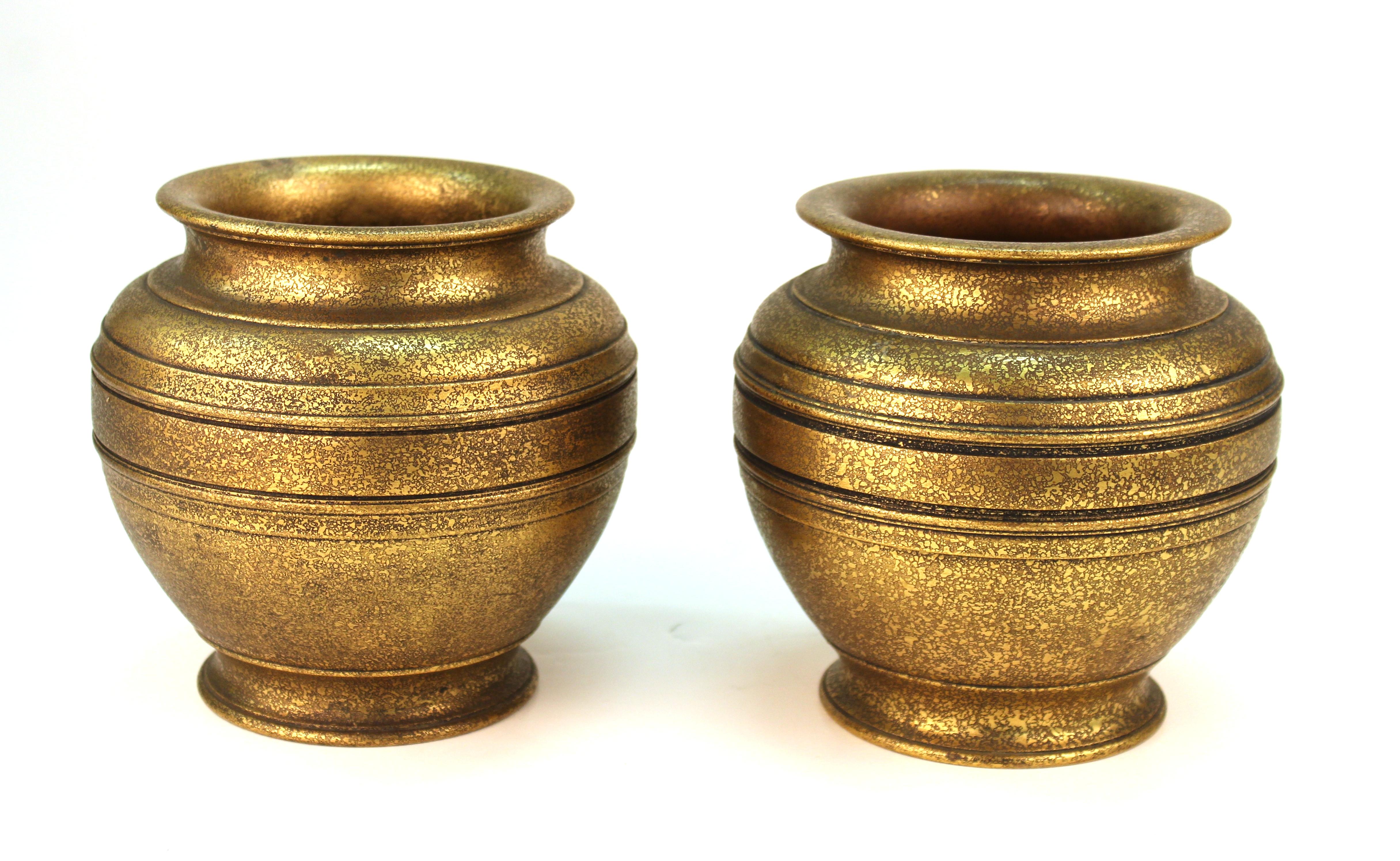 American gilded age period pair of Tiffany urns made in heavy cast gilt bronze. This rare pair was made in the Tiffany Studios in New York City during the 1900s-1910s, one of them having a darker brown patina. Both are stamped on the bottom 
