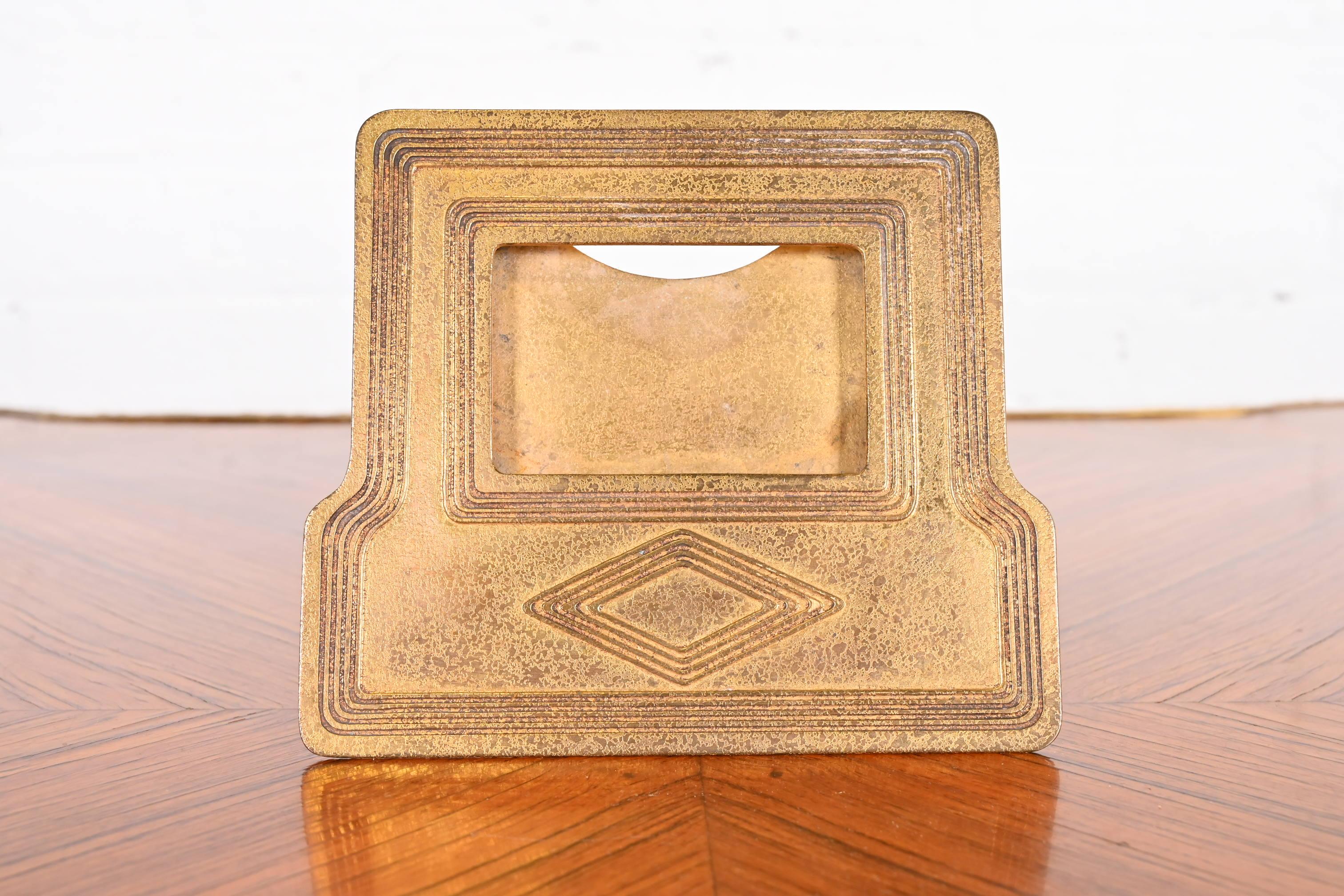 Ein prächtiger antiker vergoldeter Bronze-Tischkalenderrahmen oder Bilderrahmen im Graduate-Muster

Von Tiffany Studios (signiert en verso)

New York, USA, Anfang des 20. Jahrhunderts

Maße: 6,5 