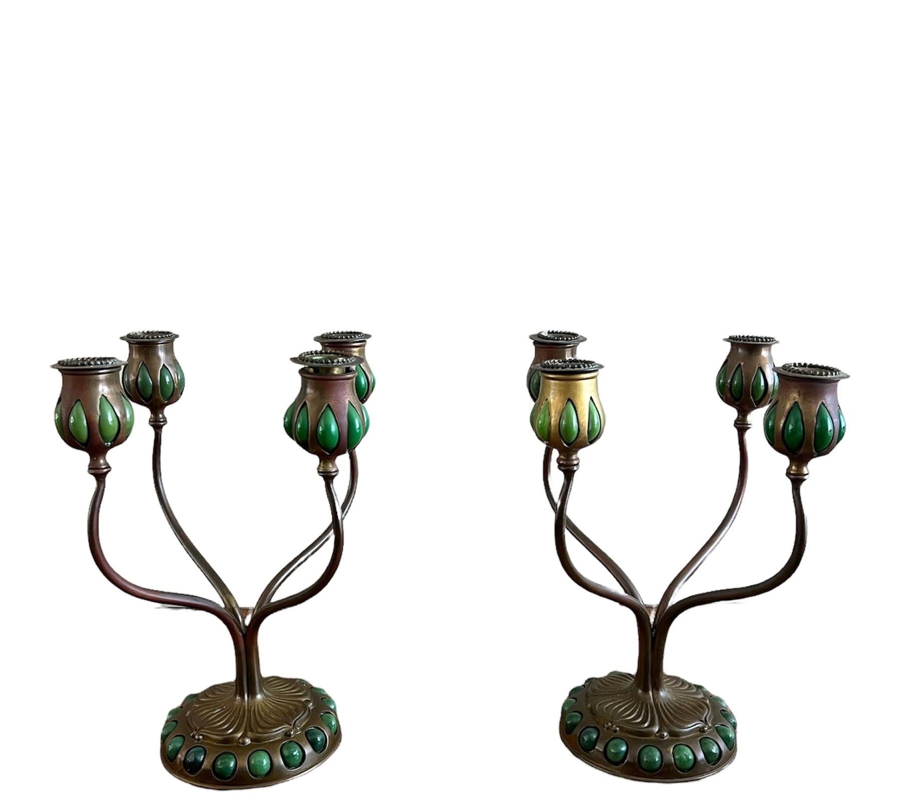 - The candleholders are made out of bronze with green favrile glass detail
- It features floral motif
- Four candle holders in each arm
-  Boyj candlesticks signed on the bottom: Tiffany Studios New York and numbered D556 4 & D556