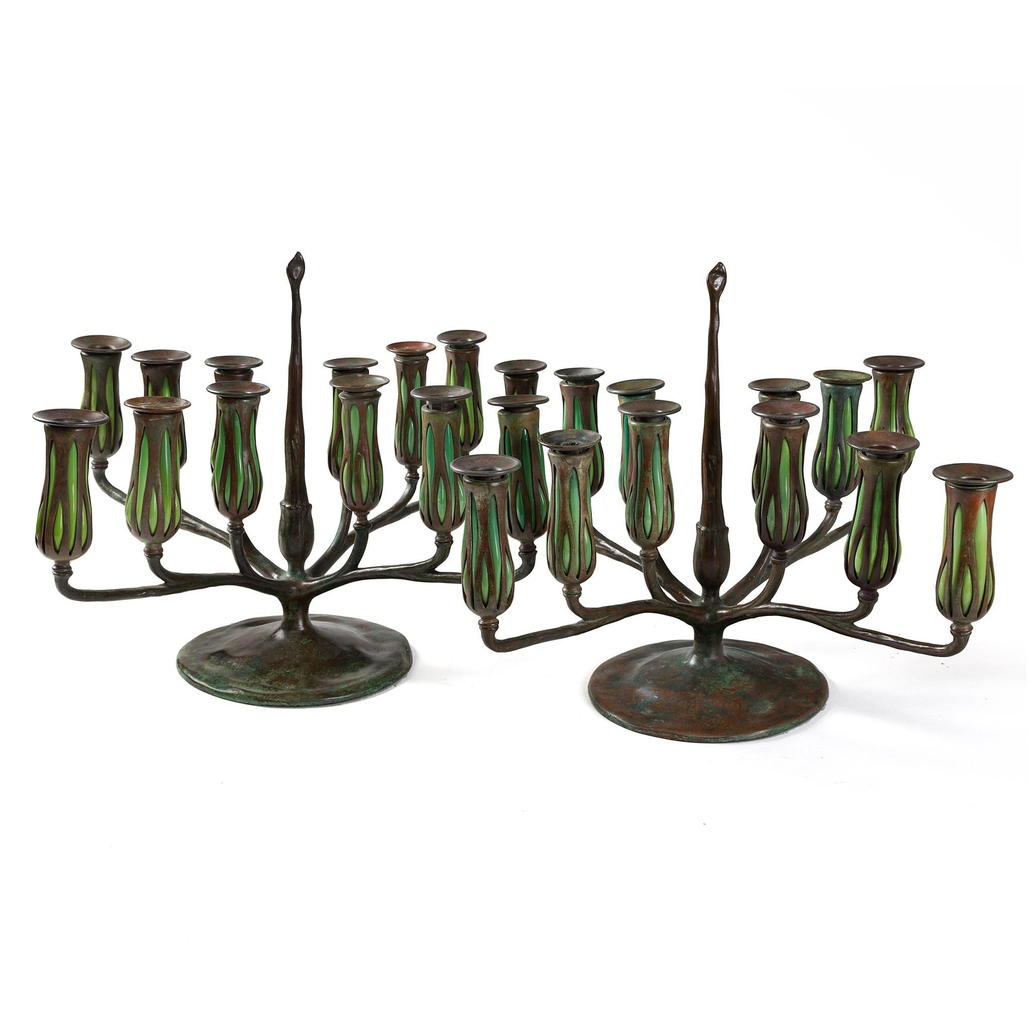 This pair of Tiffany Studios’ Twelve-light candelabrum features twelve green Favrile blown-glass bobechés that mimic the silhouette of a closed flower in bloom. Tiffany’s blown glass bronzes were the culmination of years of experimentation. Starting