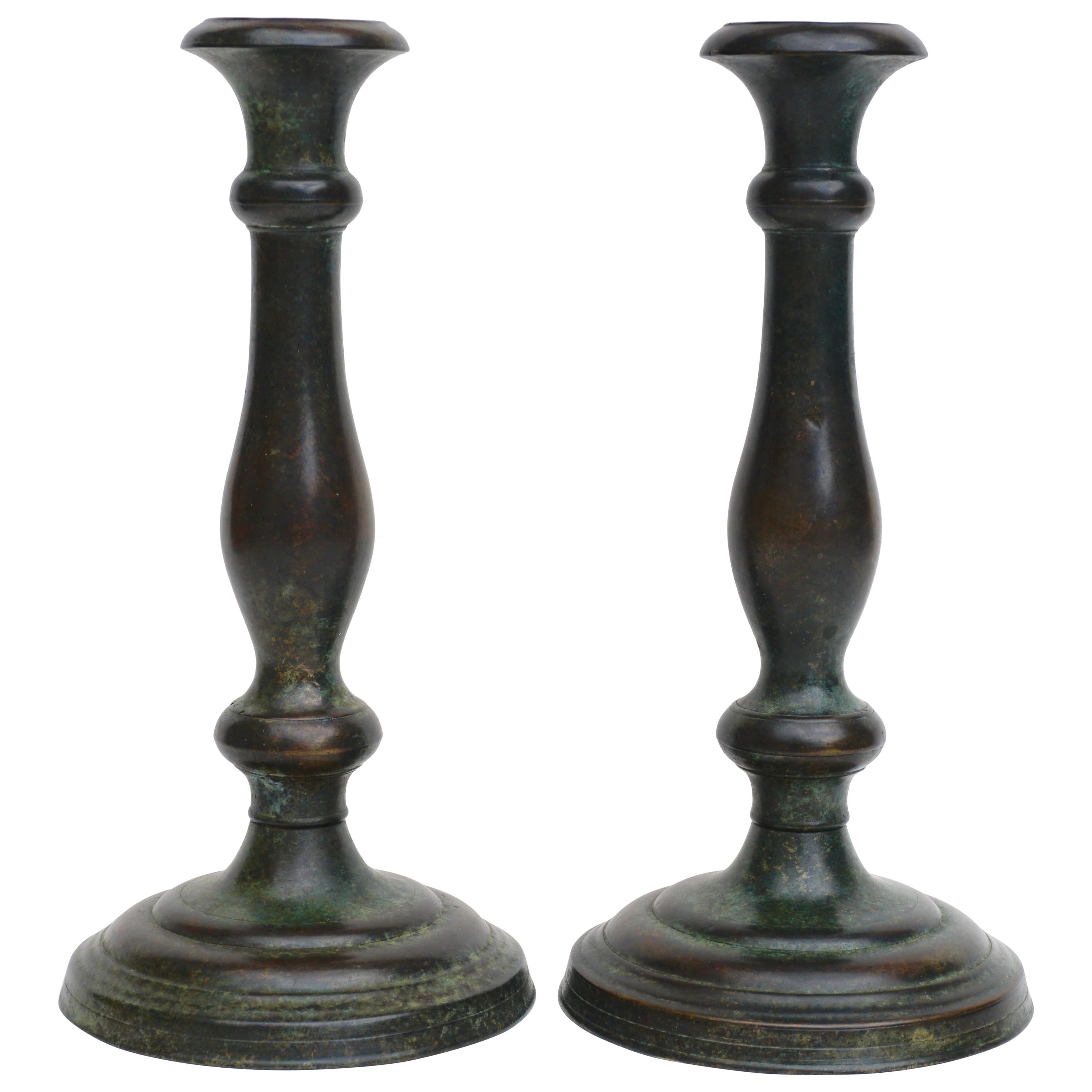 A rare pair of Art Nouveau heavy cast patinated brown, green and umber bronze candelabra candle sticks. 

The underside marked Tiffany Studios New York conjoined with G & D CO monogram for Tiffany Glass and Decorating Company. Of simple baluster