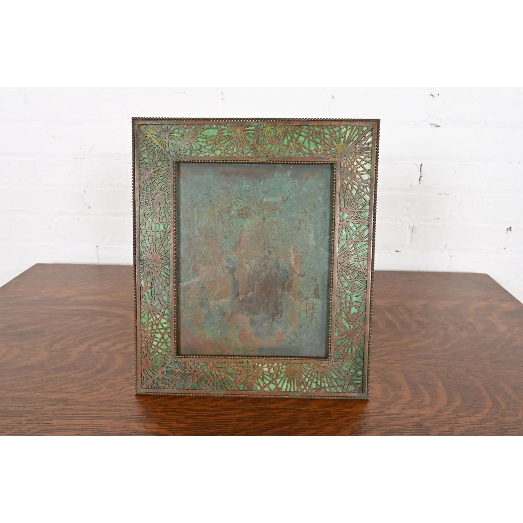 Un raro y excepcional marco grande antiguo de época Arts & Crafts

Por Tiffany Studios (firmado al dorso)

Nueva York, EE.UU., Principios del siglo XX

Bronce patinado en el icónico diseño de agujas de pino, con hermoso cristal de escoria