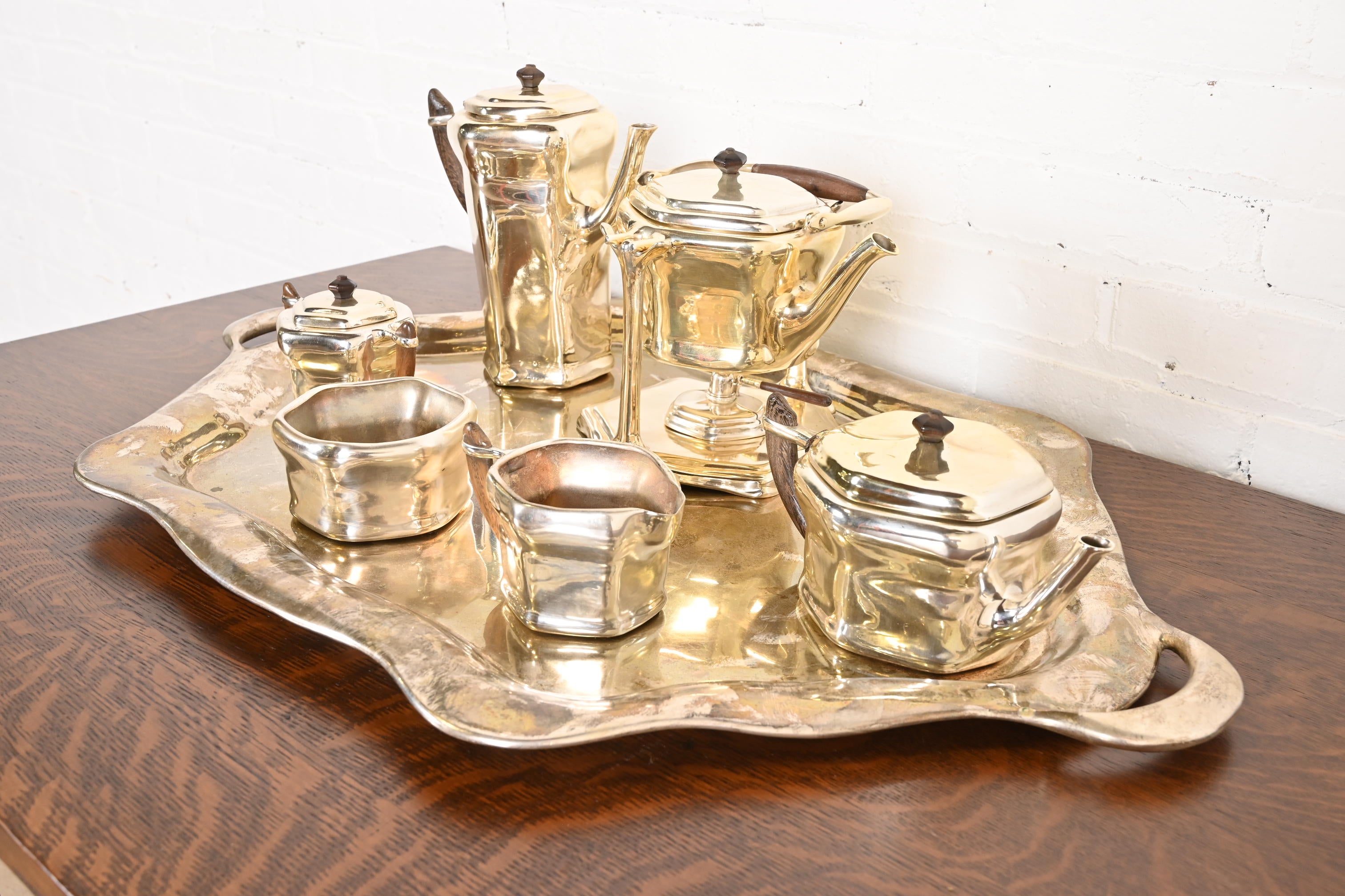 A gorgeous antique Arts & Crafts period silver plated copper tea or coffee service set, including: coffee holder, tea holder, tea pot, sugar, creamer, bowl, and large service tray.

By Tiffany Studios (each piece signed to the underside)

USA, Circa