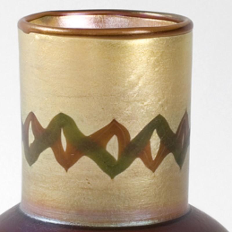 A Tiffany Studios New York “Tel el Amarna” vase featuring iridescent brown, coffee and gold Favrile glass with an Egyptian-inspired motif.     

 A vase with similar colors and decoration is pictured in: 