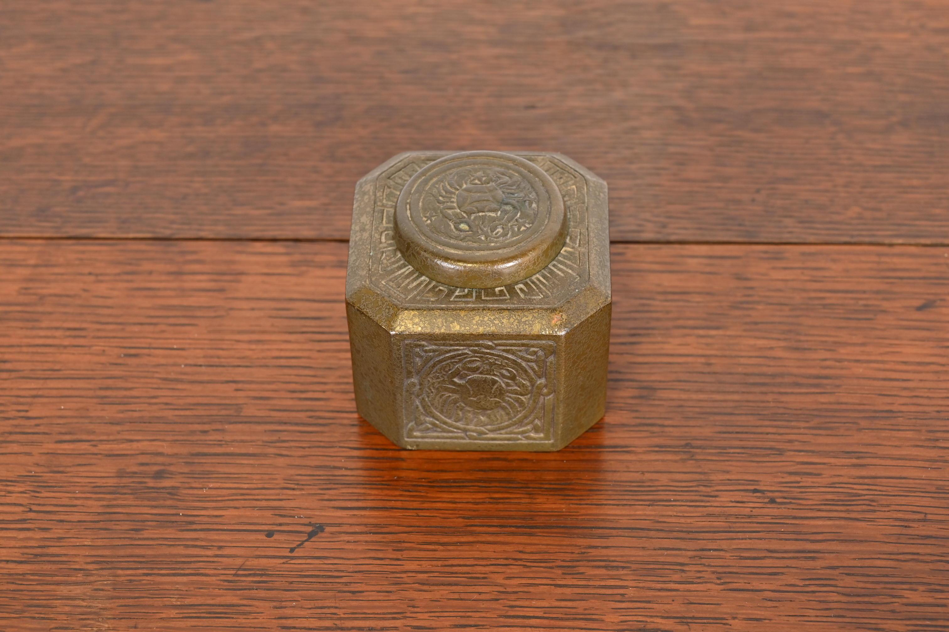 Un magnifique encrier en bronze antique avec des motifs de Zodiac.

Par Tiffany Studios (signé sur le dessous)

New York, États-Unis, Début du XXe siècle

Dimensions : 3 
