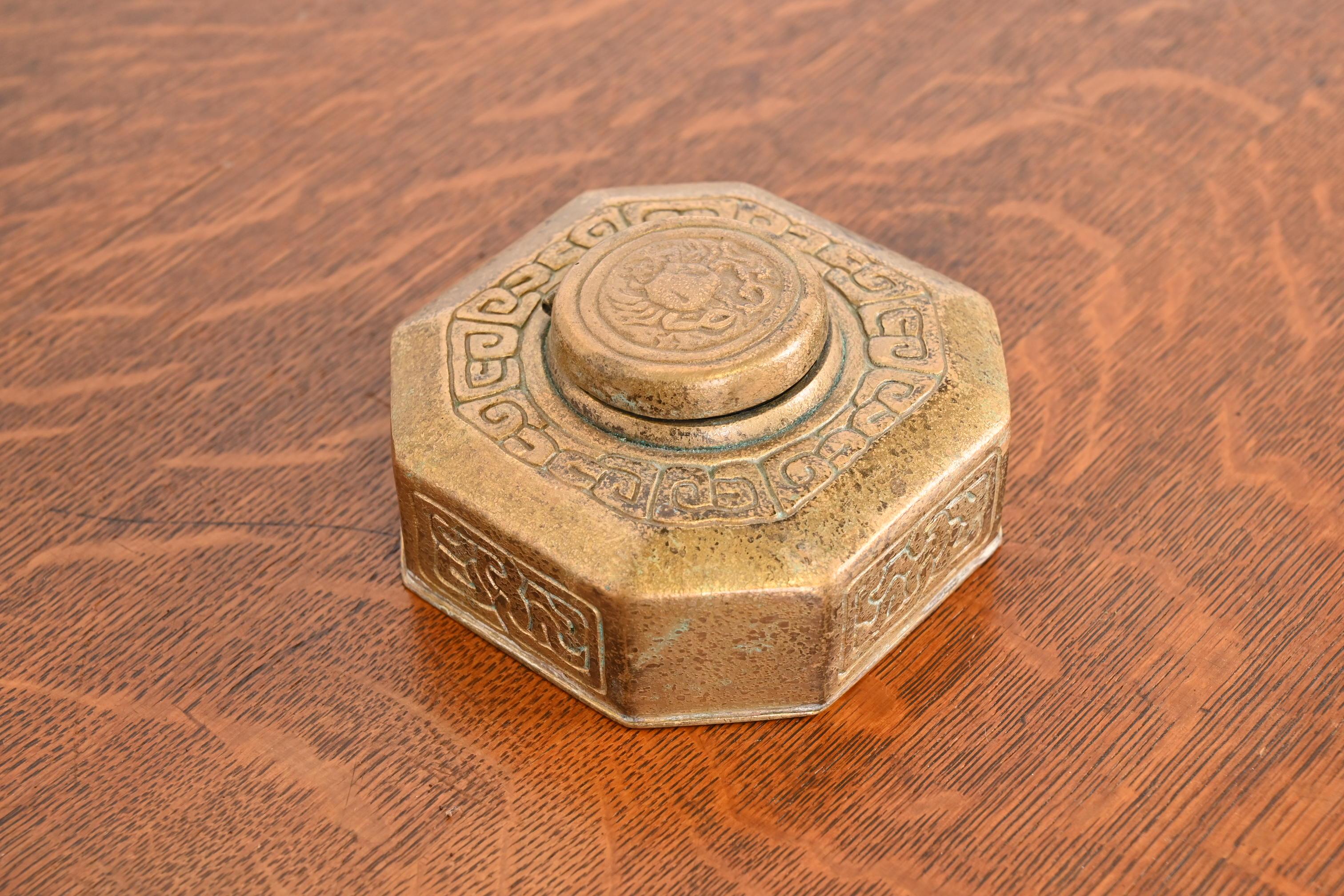 Magnifique encrier ancien en bronze doré avec des motifs du Zodiac.

Par Tiffany Studios (signé sur le dessous)

New York, États-Unis, Début du XXe siècle

Mesures : 4,25 