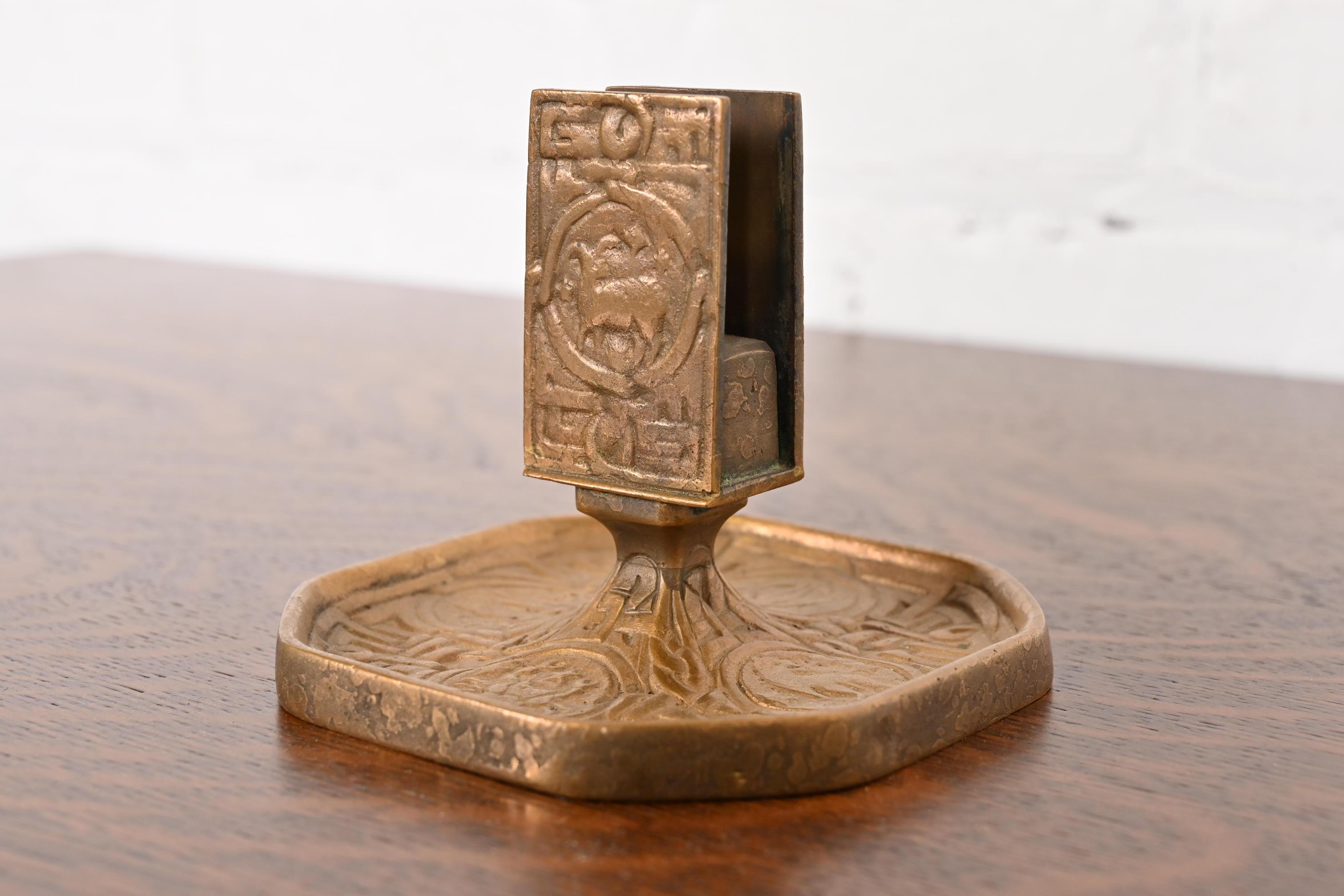 Uno splendido porta fiammiferi in bronzo dorato di epoca Arts & Crafts o Art Deco con simboli dello Zodiaco

Di Tiffany Studios (firmato sul lato inferiore)

New York, USA, inizio del XX secolo

Misure: 5