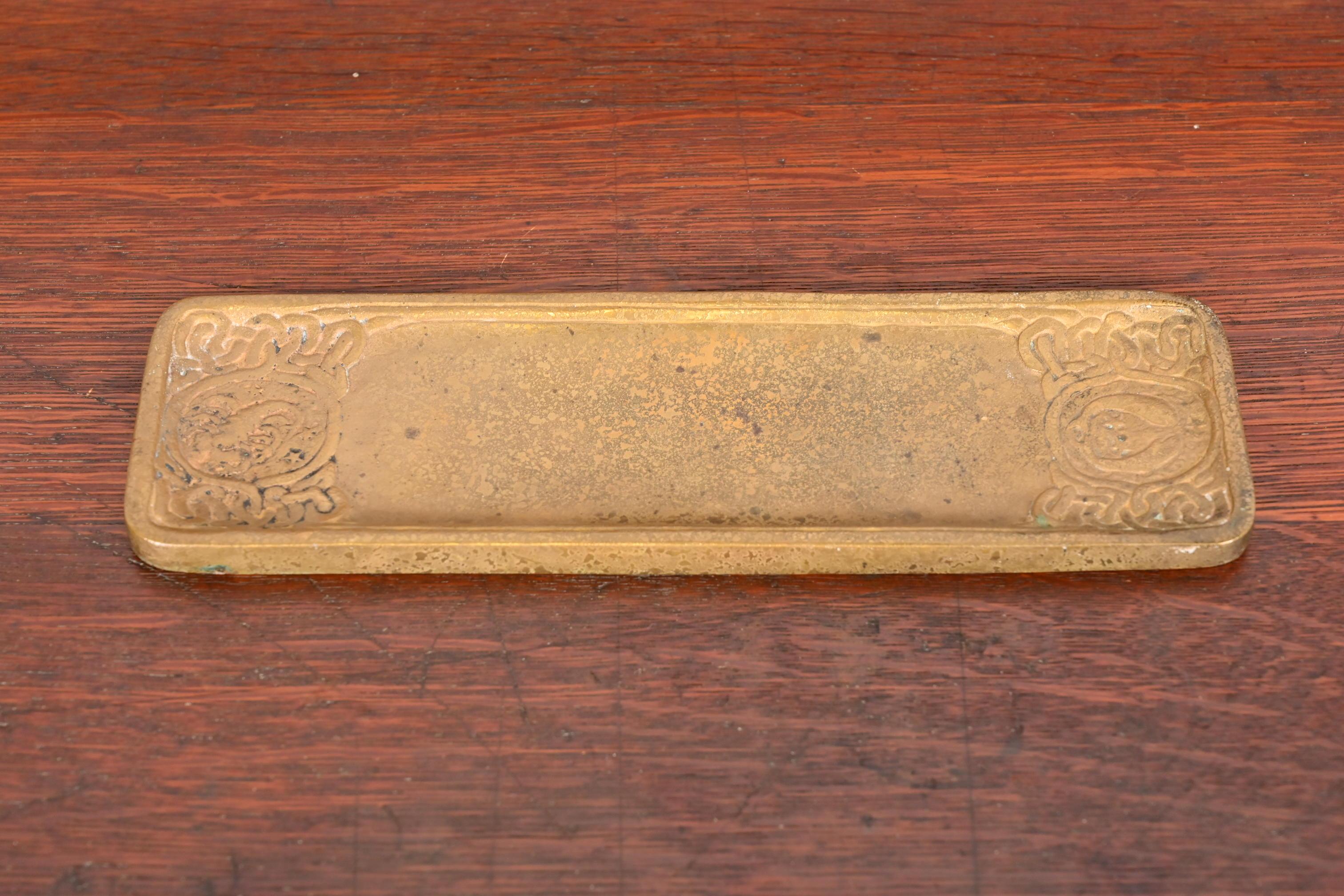 Magnifique plumier ancien en bronze doré avec des motifs de Zodiac.

Par Tiffany Studios (signé sur le dessous)

New York, États-Unis, Début du XXe siècle

Mesures : 10,25 