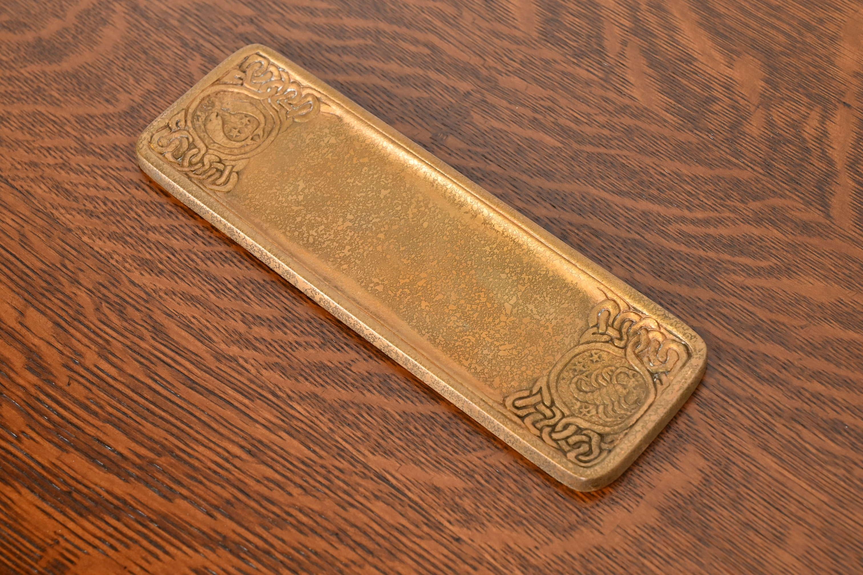 Magnifique plumier ancien en bronze doré avec des motifs de Zodiac.

Par Tiffany Studios (signé sur le dessous)

New York, États-Unis, Début du XXe siècle

Mesures : 10 