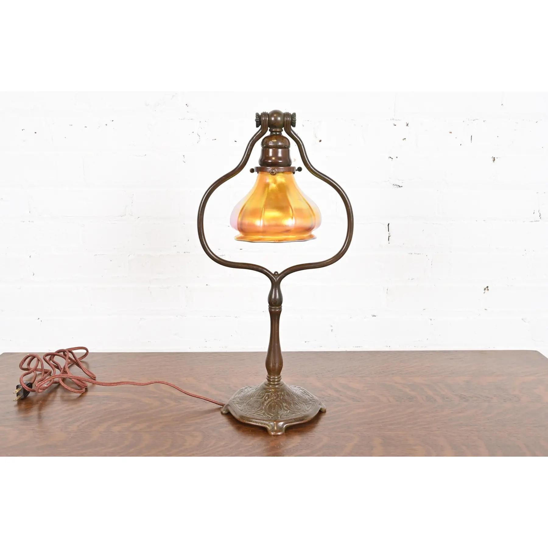 A rare and exceptional Arts & Crafts or Art Deco period bronze harp desk lamp or table lamp

By Tiffany Studios (signed to the underside of base)

New York, USA, Early 20th Century

Bronze base in Zodiac pattern, with beautiful iridescent Favrile