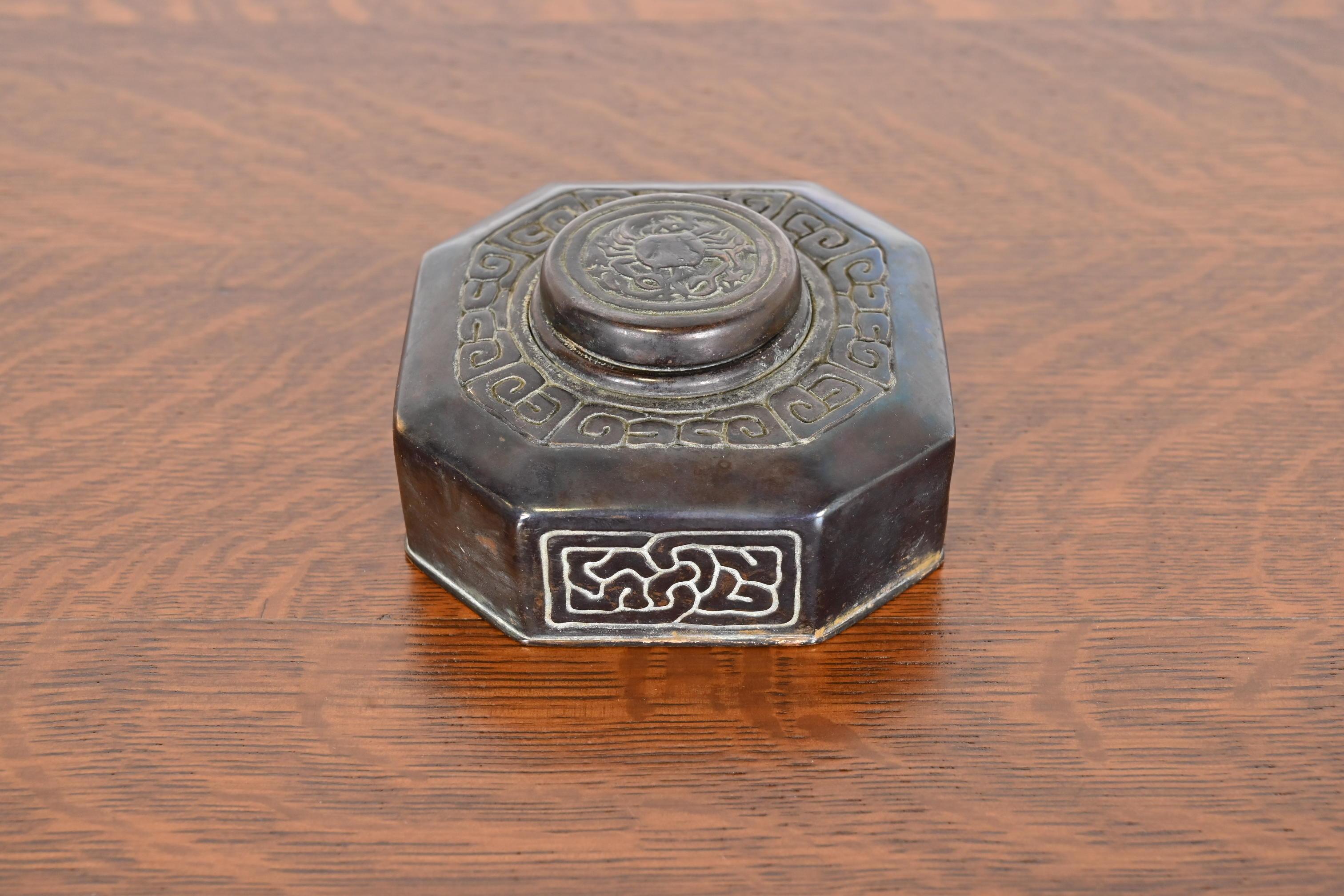 A gorgeous Art Deco period patinated bronze inkwell featuring symbols of the Zodiac

By Tiffany Studios

New York, USA, early 20th century

Measures: 4