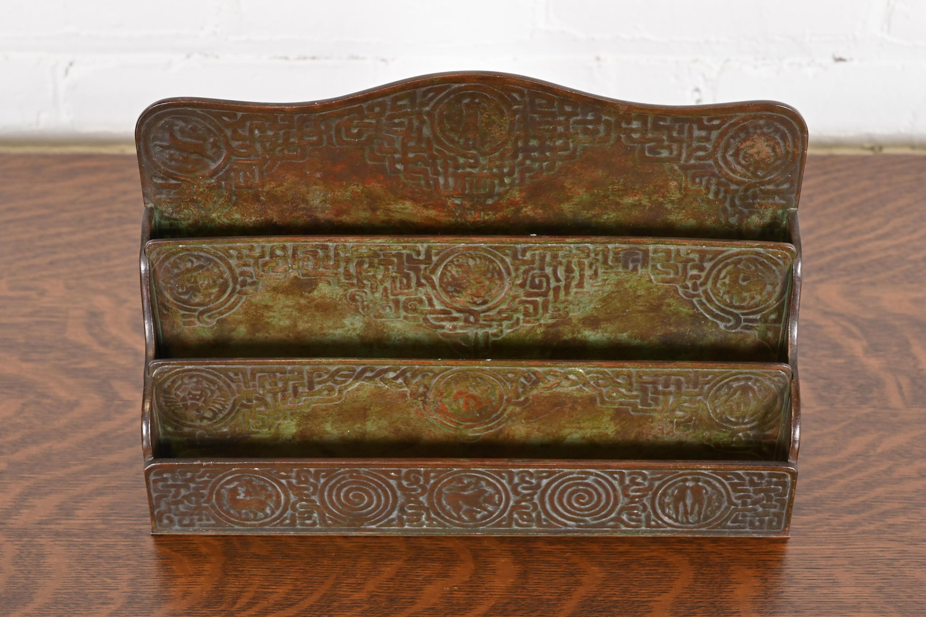 Magnifique porte-lettres de bureau en bronze patiné, d'époque Arte & Crafts ou Art Deco, avec des motifs de Zodiac.

Par Tiffany Studios (signé sur le dessous)

New York, États-Unis, Début du XXe siècle

Mesures : 12,13 