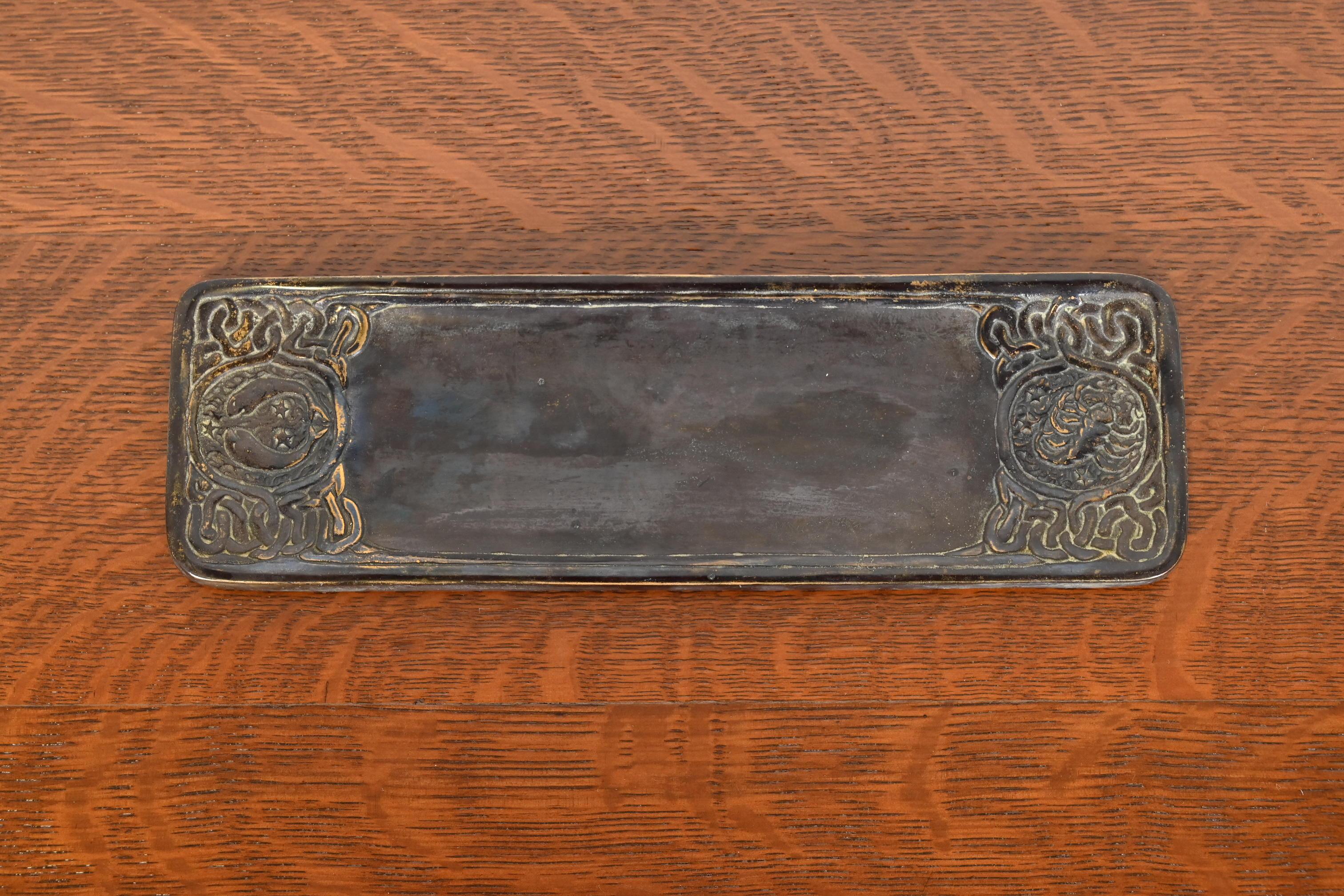 A gorgeous Art Deco period patinated bronze pen tray featuring symbols of the Zodiac.

By Tiffany Studios

New York, USA, Early 20th century

Measures: 10.13