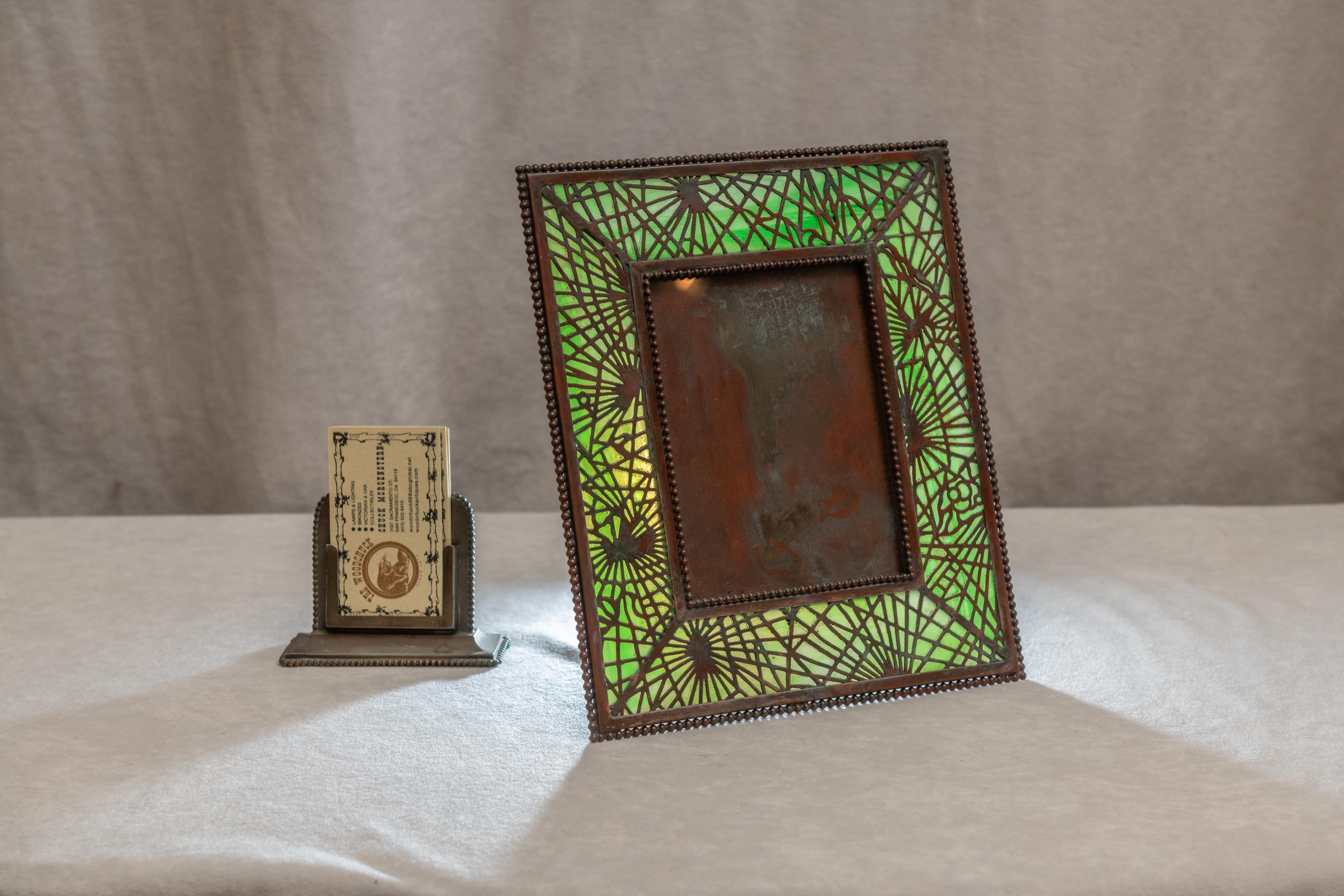 Another fine example of the workmanship of the great Tiffany Studios. This is Louis Comfort Tiffany, not to be confused with Tiffany Co., a dept. store. That was his dad. Tiffany Studios was known for his lamps and great glass. This frame has glass