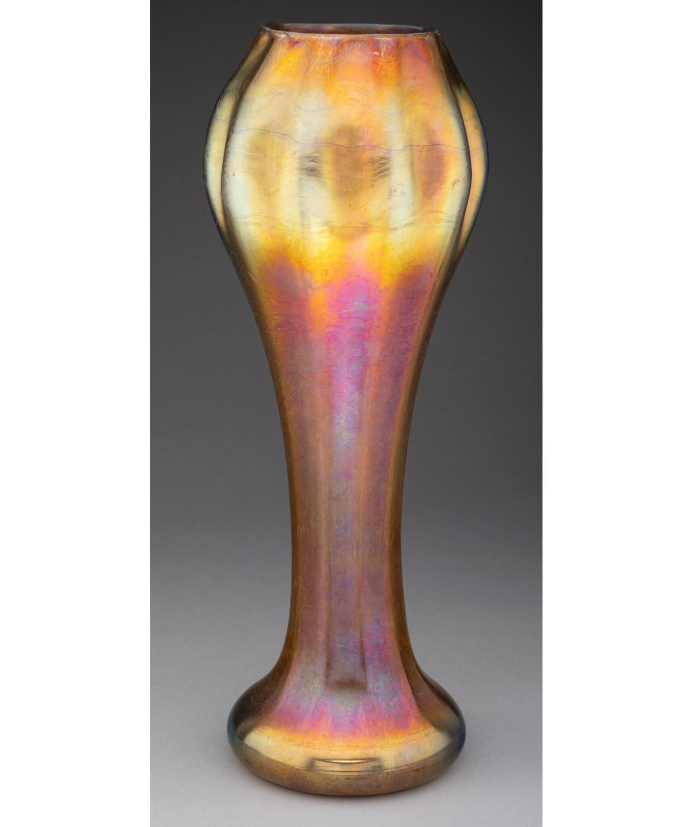 Vaso di vetro floriforme rosso e oro iridescente di grandi dimensioni di Tiffany Studios by Louis Comfort Tiffany. Si tratta di una forma rara e di un colore rosso che sarà un'aggiunta imperdibile per il collezionista esigente di Tiffany. 
Vaso