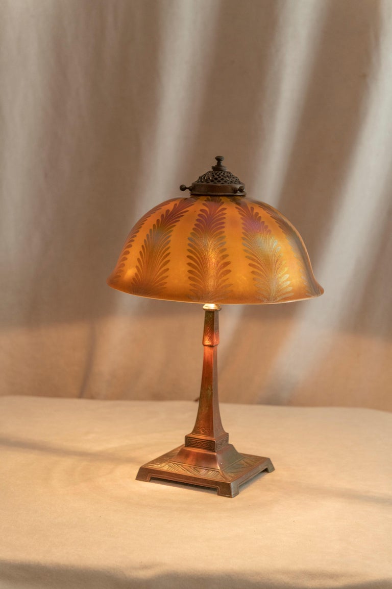  This lovely little Tiffany lamp can be put almost anywhere in your home. The  bronze base has a rich warm brown patina. The hand blown shade is beautiful and colorful. White lined keeping an opaque look and so the lightbulb is not visible. The