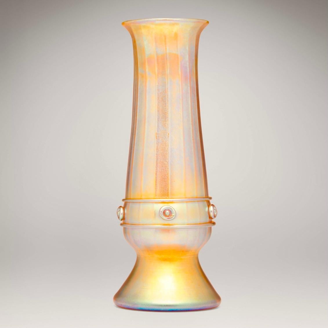 Tiffany Studios Grand vase à décor nervuré et appliqué en Favrile
Côtelée de brins de verre favrile appliqués encerclant et formant des corbochons d'escargot en bouton sur le corps.  
New York, USA, c. 1926
Verre Favrile soufflé à la main
Dimensions