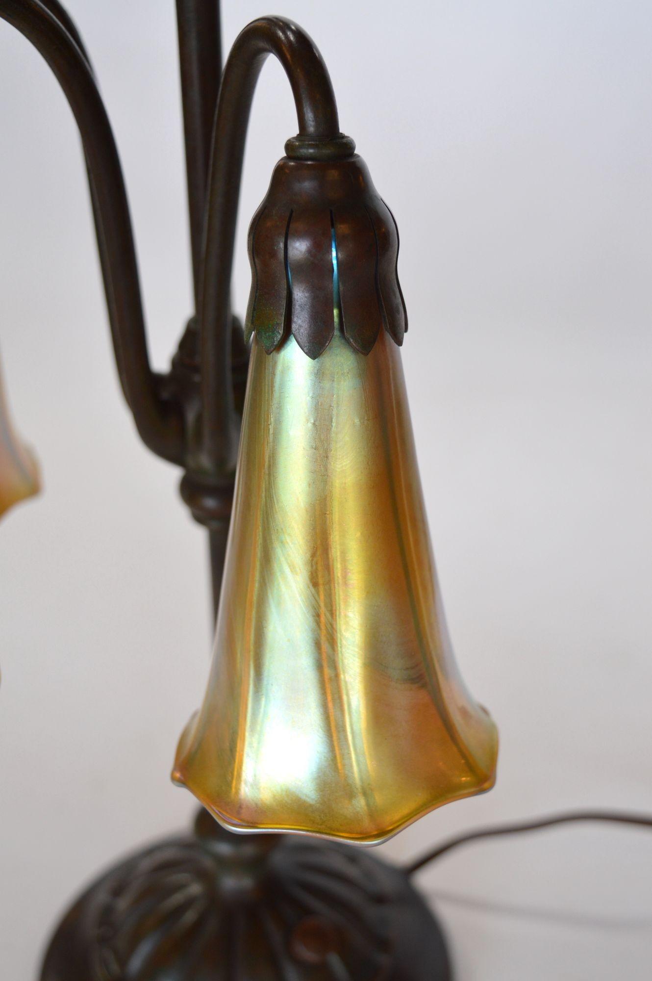 Early 20th Century Tiffany Studios Three Light Lily Bronze and Favrile Table Lamp