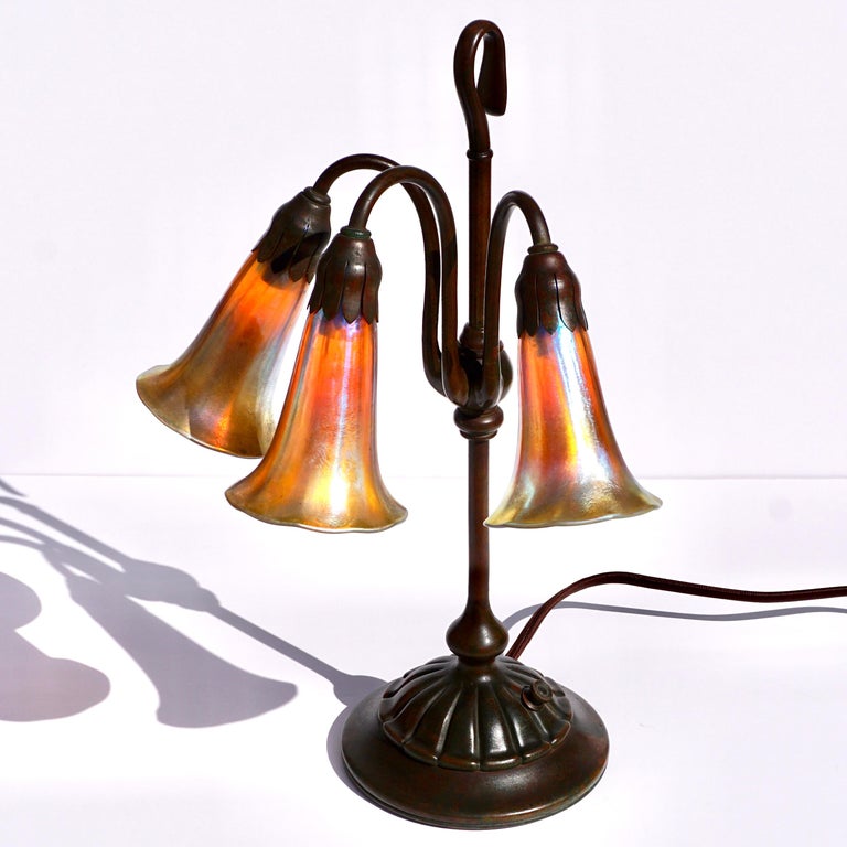 Cast Tiffany Studios Three Light Lily Favrile and Bronze Lamp For Sale