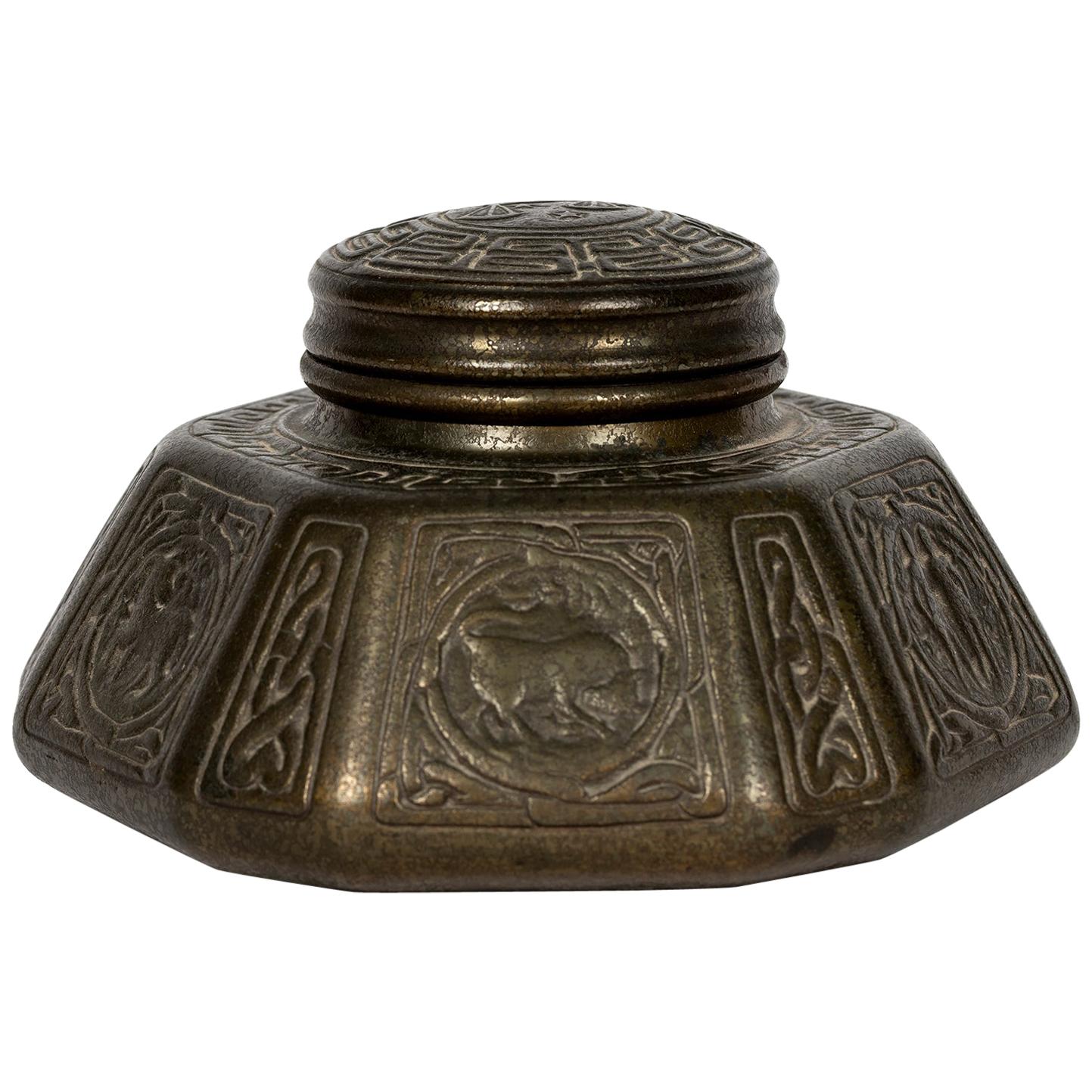 This beautiful collectable from Tiffany Studios, circa 1900s, is in cast metal with a heavily bronze patina. It is stamped on the underside Tiffany Studios 1072.
It has its original glass 