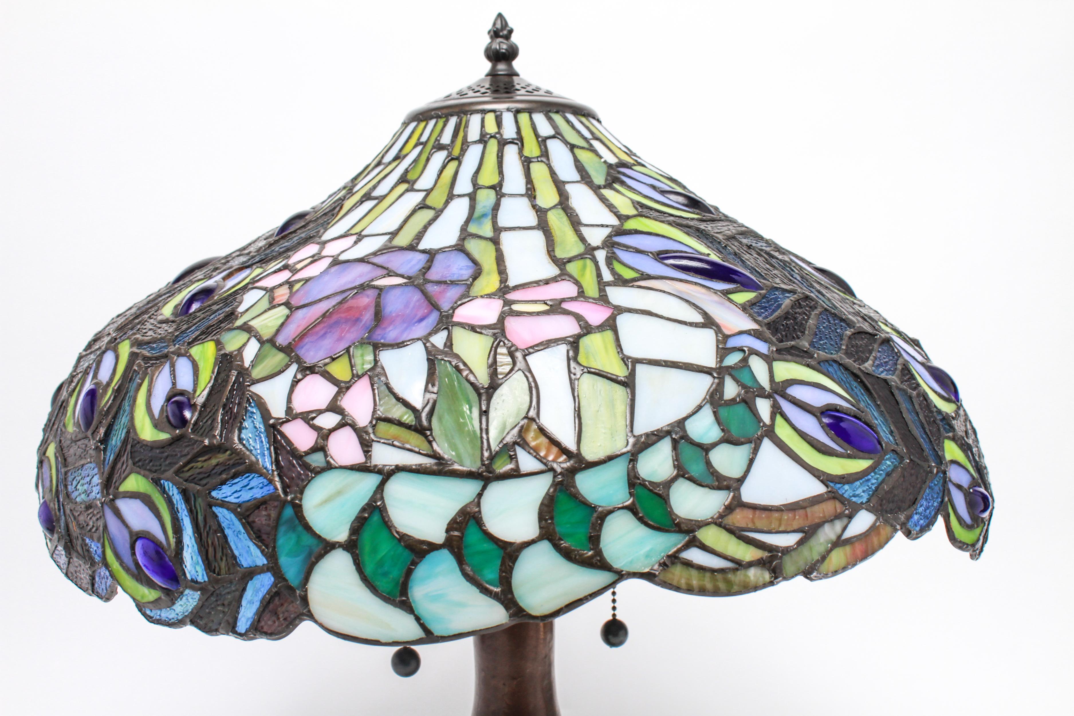 Tiffany style table lamp in American Art Nouveau style, with a patinated metal base with incorporated faux 