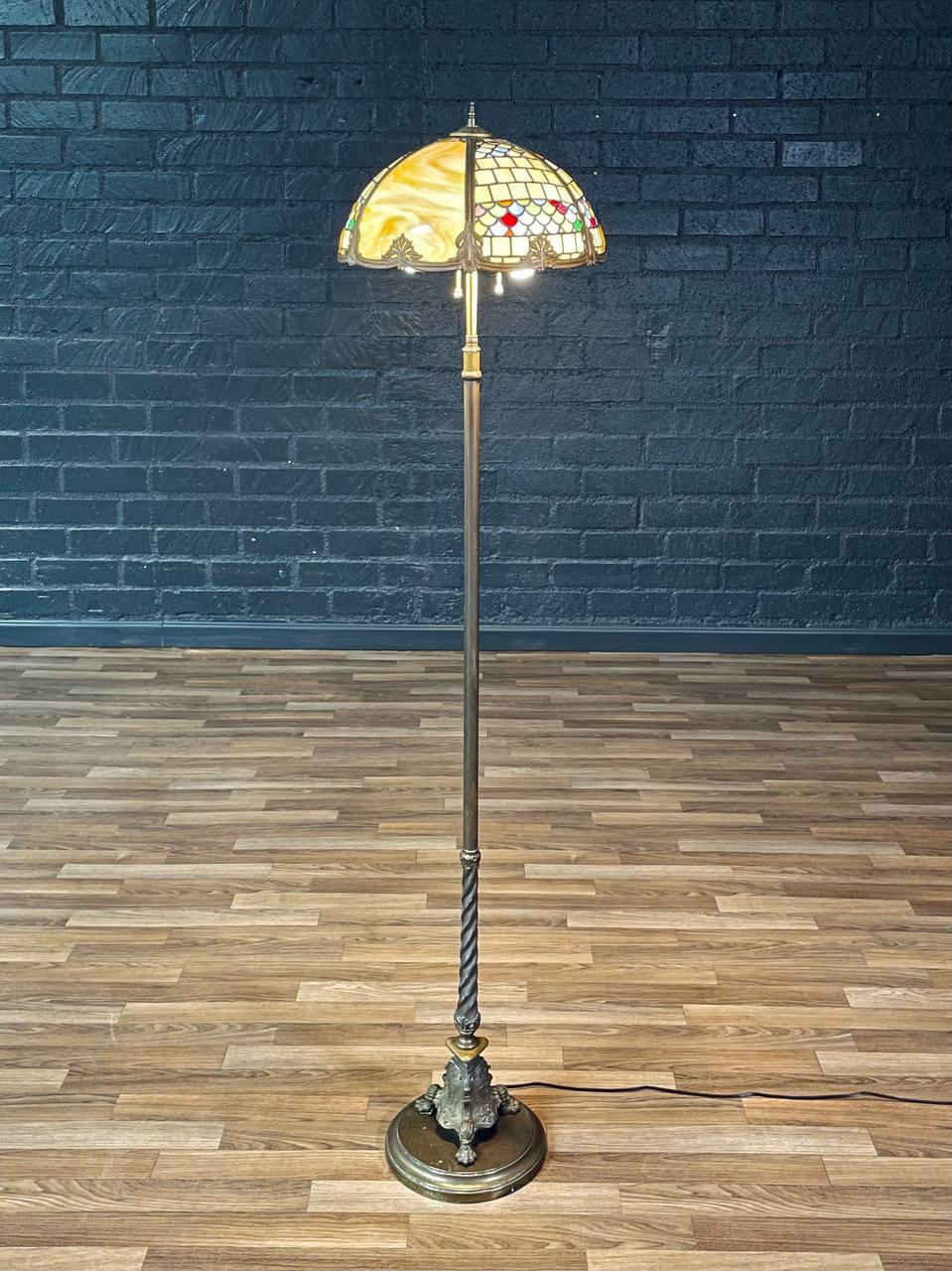 Condition: Newly Rewired 

Materials: Patinated Metal, Original Slag Glass Shade

This exquisite Tiffany-style Art Nouveau floor lamp, crafted in the United States circa 1940s, showcases an original slag glass shade with vibrant marbled and