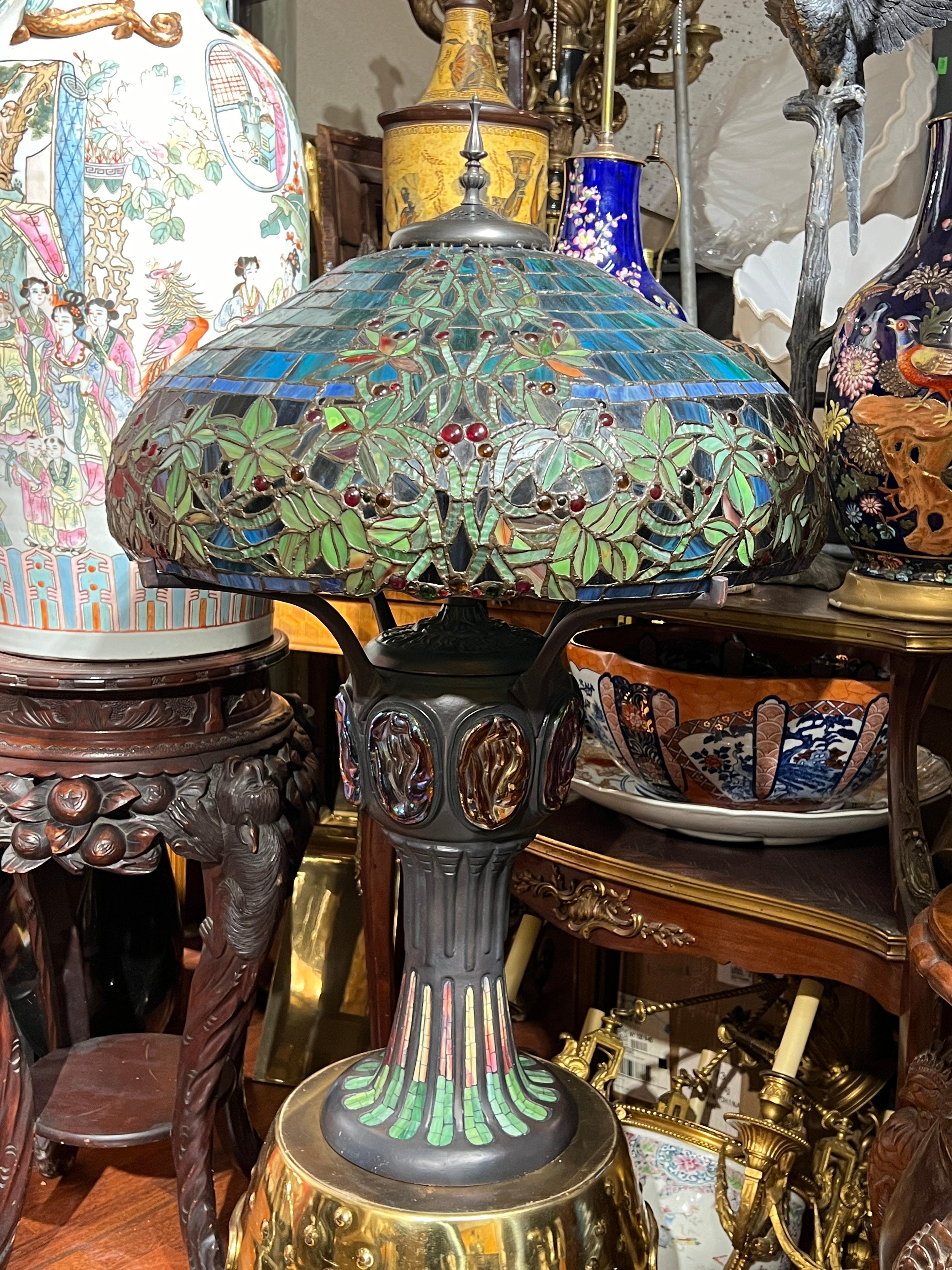 Lovely, large leaded glass table lamp after Louis Comfort Tiffany with shade featuring berry vine motif and standard with iridescent turtleback glass.  34 1/2 inches tall and 22 inches across and in excellent condition.