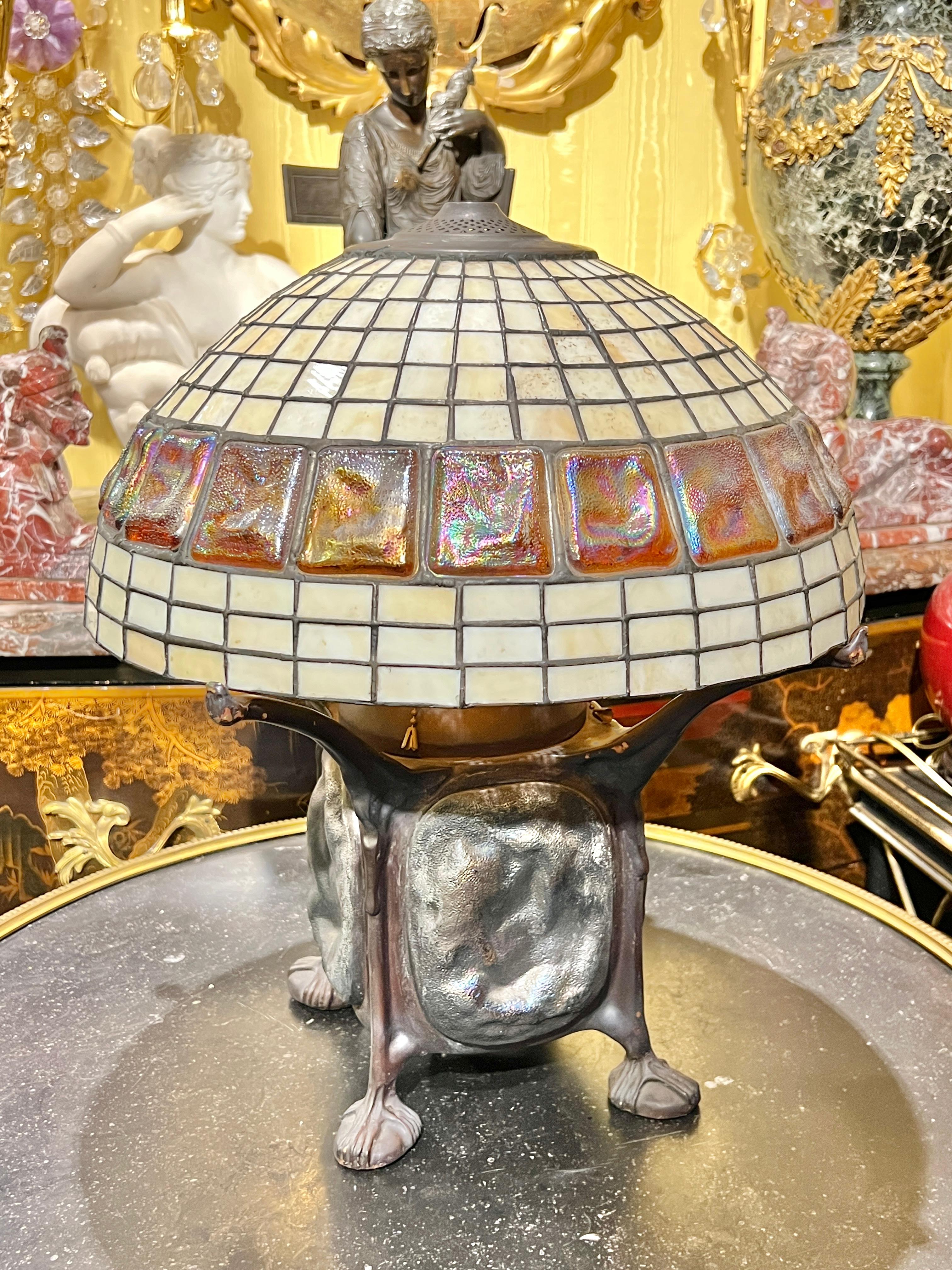 Tiffany style bronze table lamp with dome-shaped leaded glass shade inset with iridescent turtle back glass.  15 inches across and 18 inches tall.