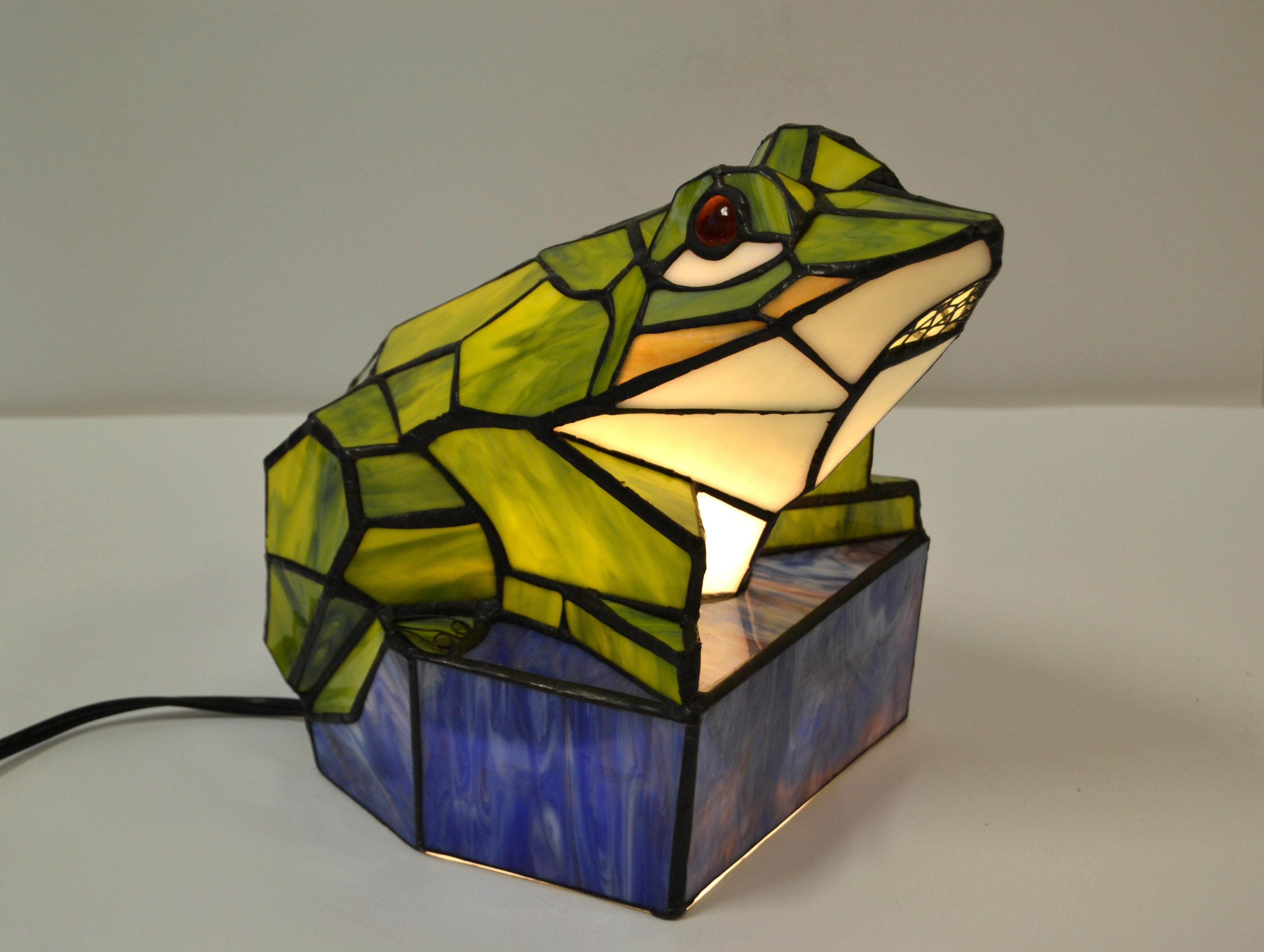 Stained green and blue art glass frog table lamp animal sculpture lamp.
Perfect working condition US wiring and takes one-light bulb with max. 40 watts.
This lamp brings joy to each children's room.