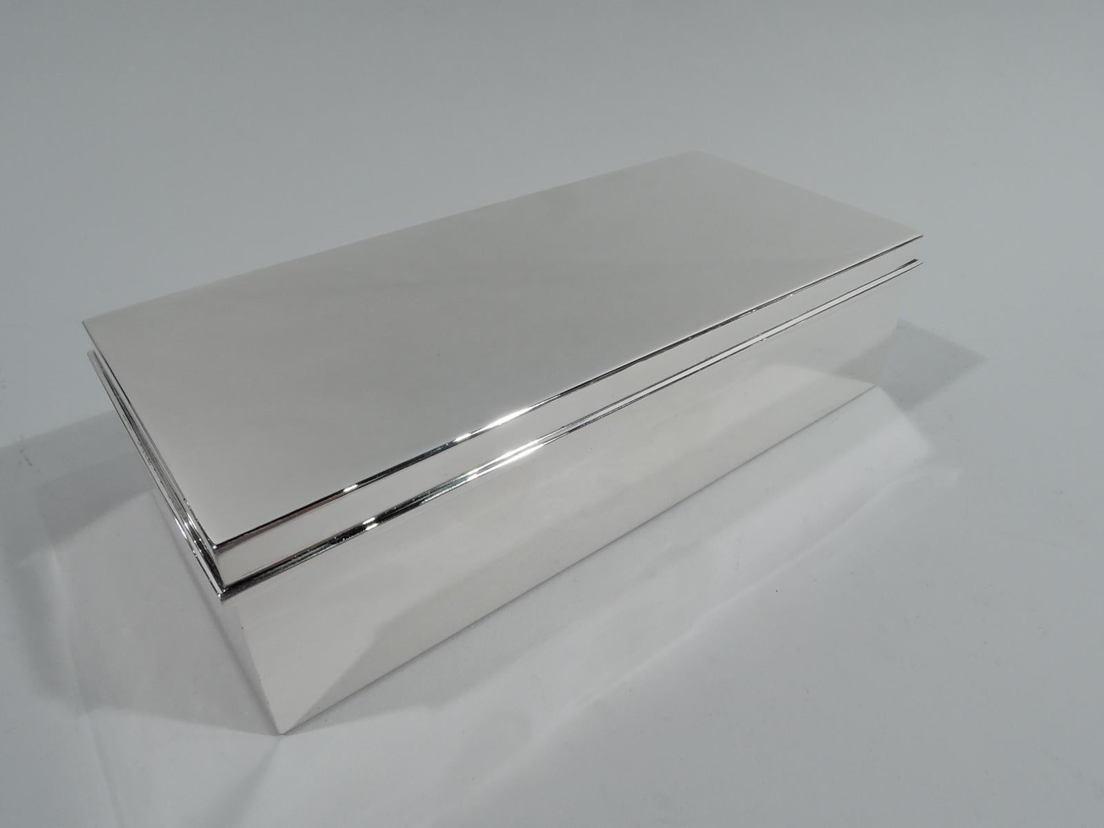 Stylish Mid-Century Modern sterling silver desk box. Made by Tiffany & Co. in New York. Rectangular with straight sides. Cover flat and hinged with molded rim. Box interior cedar lined and partitioned. Cover interior gilt. Fully marked including