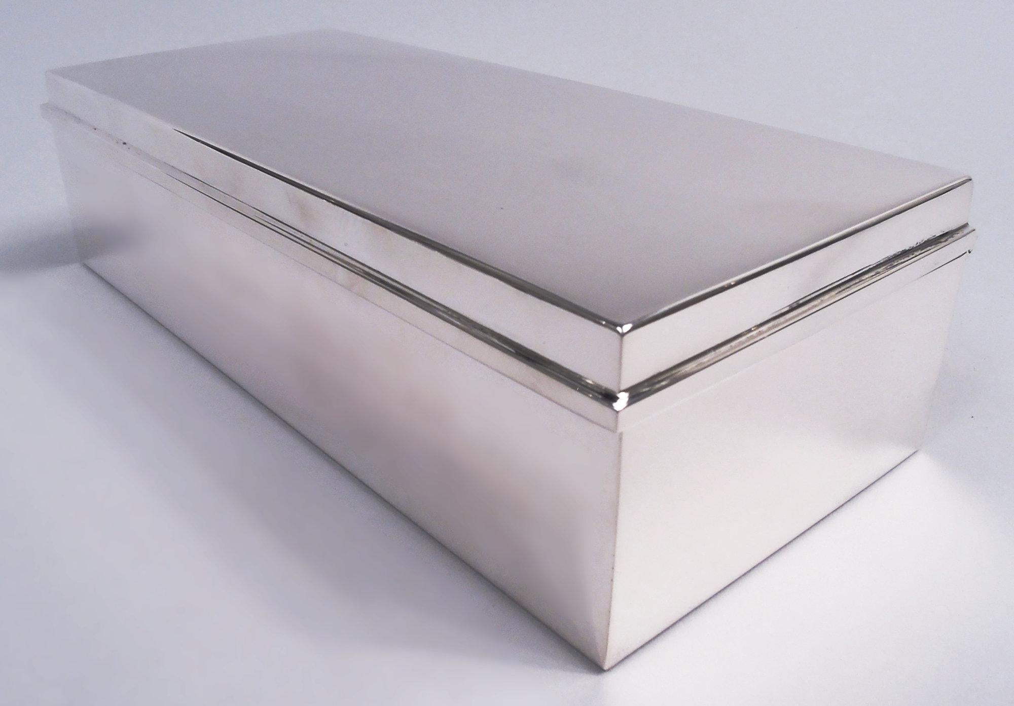 Midcentury Modern sterling silver desk box. Made by Tiffany & Co. in New York. Rectangular with straight sides. Cover flat and hinged with rectilinear rim. Box interior cedar lined and partitioned. Cover interior gilt. Fully marked including maker’s